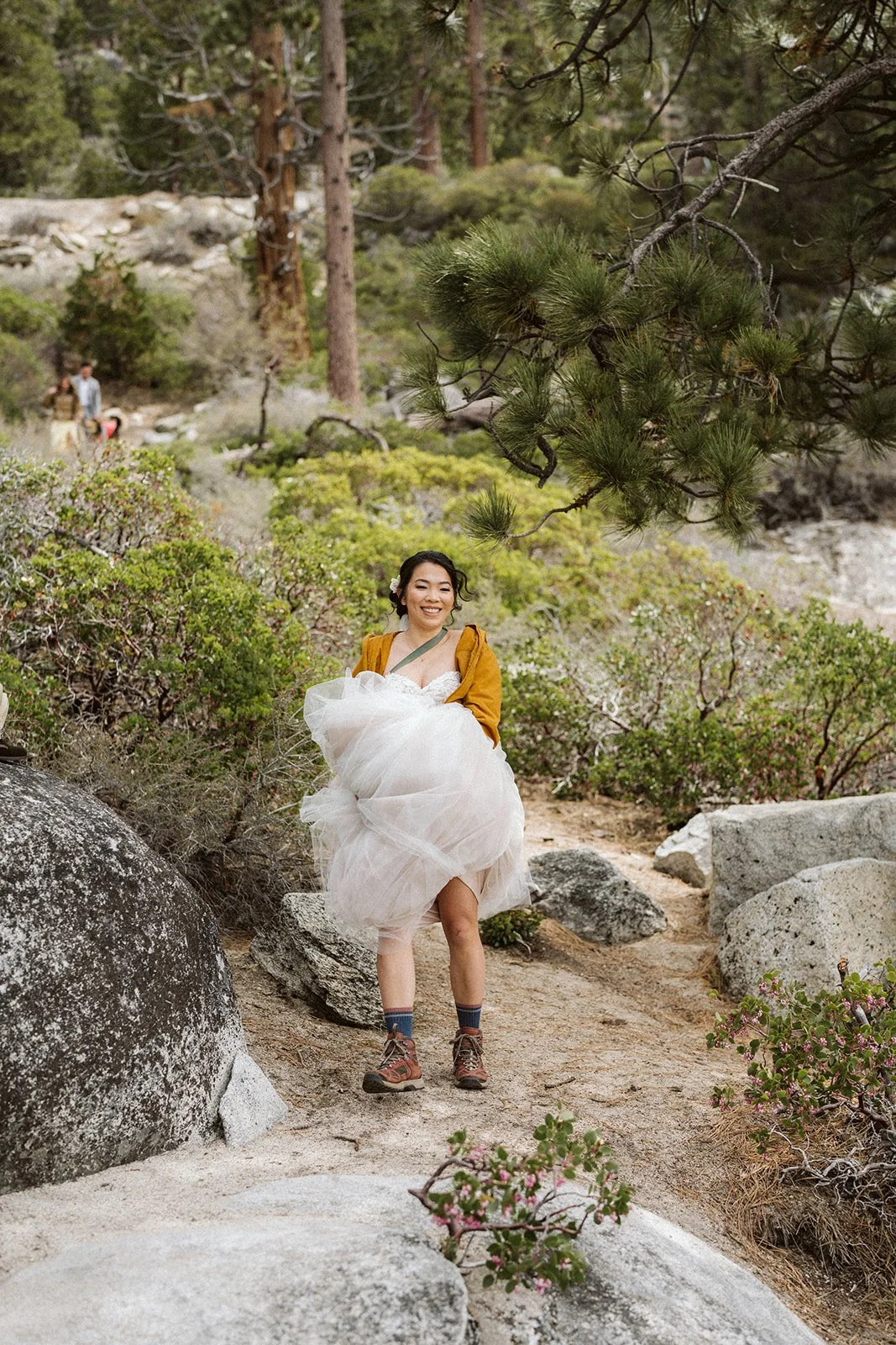 Bride in wedding dress and hiking boots on Lake Tahoe trail, adventure elopement — AJ Photography