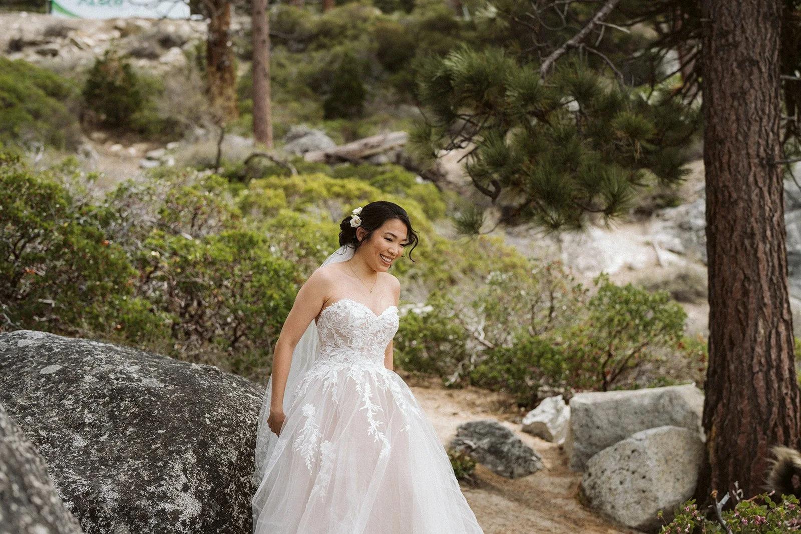 Bride laughing and walking through Lake Tahoe forest during elopement day — AJ Photography