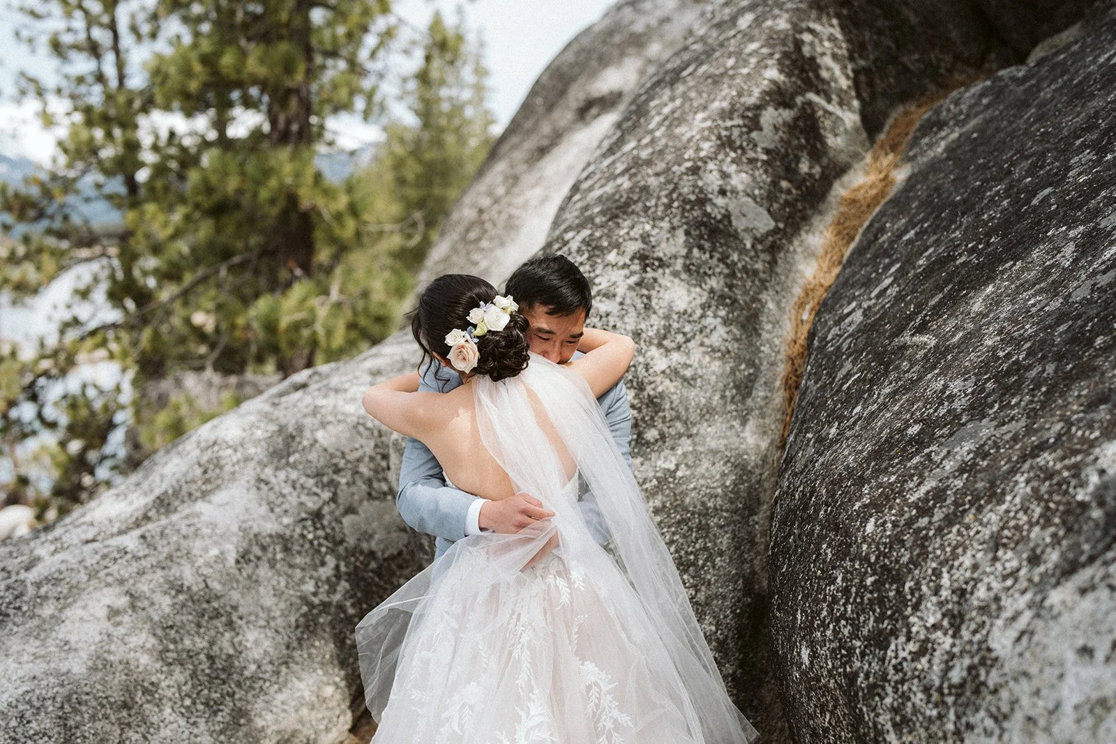 Couple embracing between granite boulders during Lake Tahoe elopement — AJ Photography