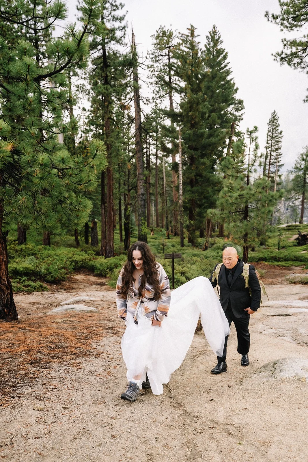 Bride walking through Yosemite Valley forest trail during elopement — AJ Photography