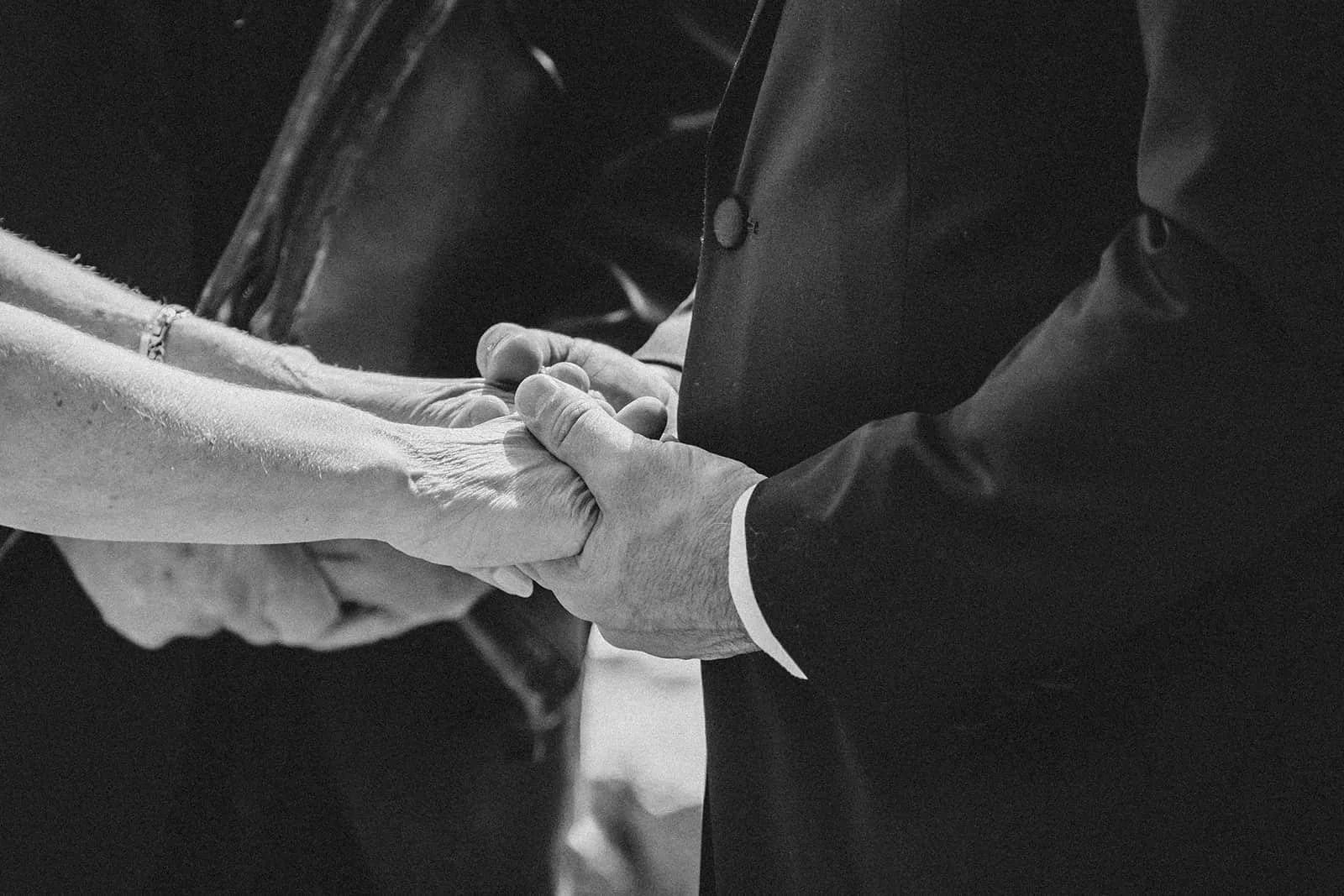 black and white of hand holding during ceremony.jpg