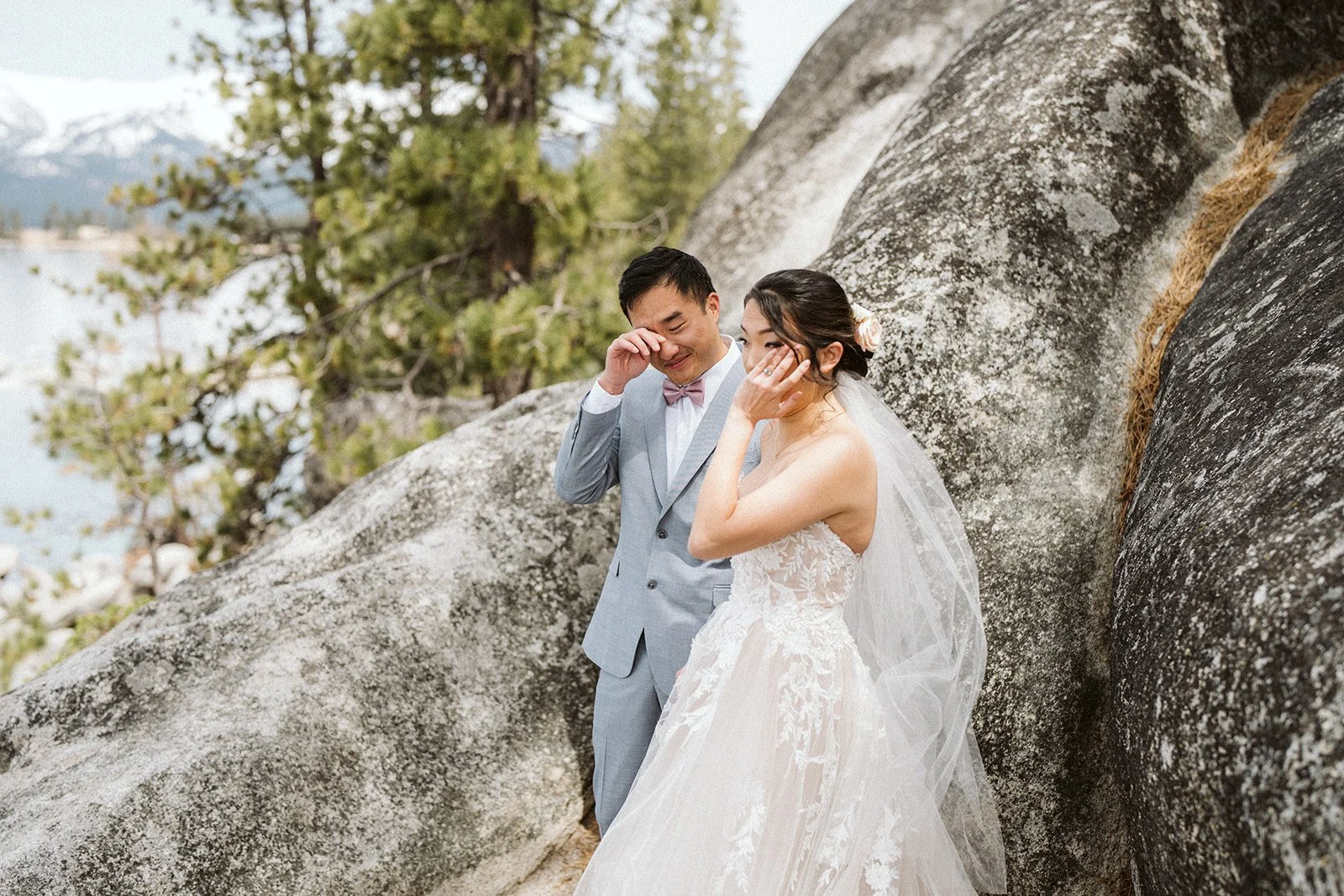 Bride and groom beside granite rocks with snow-capped Sierra Nevada in background, Lake Tahoe elopement — AJ Photography