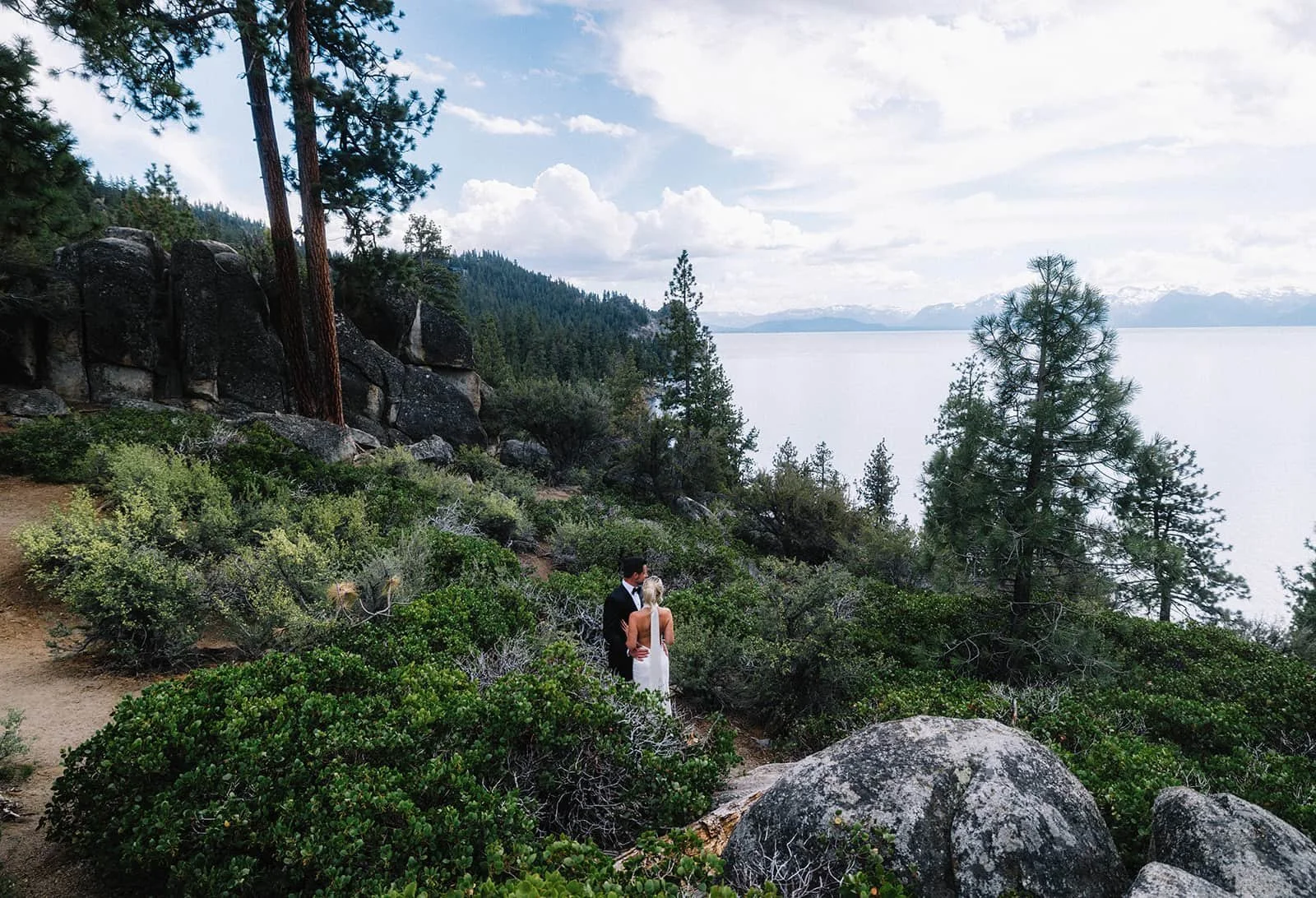 bride and groom in meadow overlooking lake tahoe.jpg