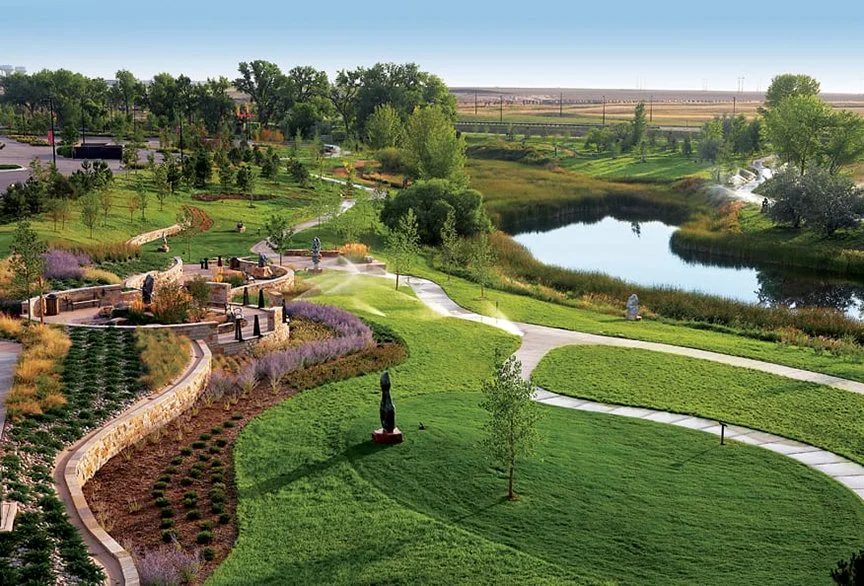 Centerra Land Development green space with a pond, trees, and gardens.