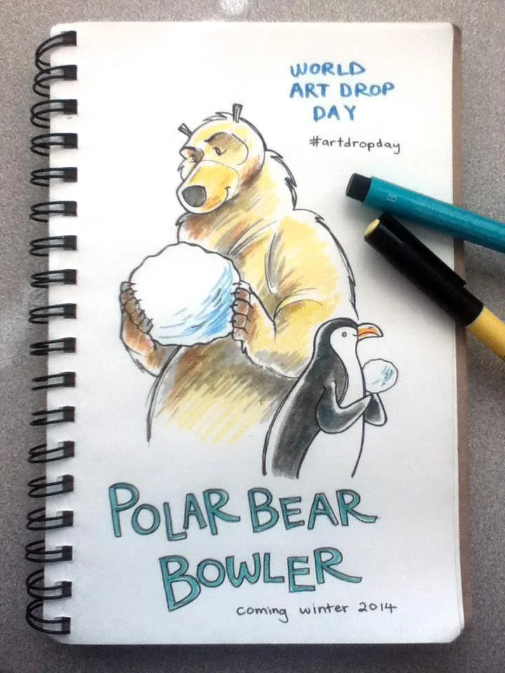 A sketchbook open to a marker drawing of the polar bear with a snowball, and a penguin with a smaller snowball. Text reads: "World Art Drop Day #ArtDropDay. Polar Bear Bowler, coming winter 2014."