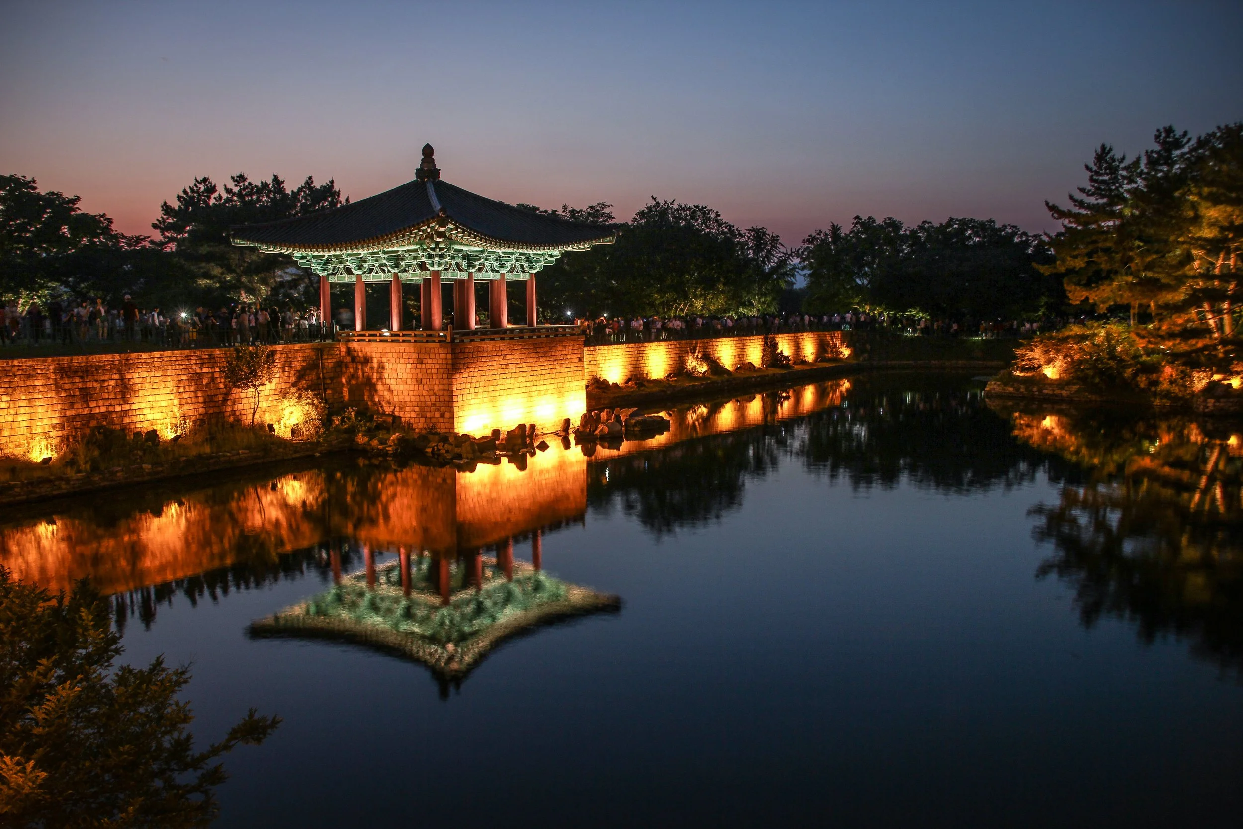 Illuminated traditional Korean pavilion reflected in the still waters of Anapji Pond at dusk, Gyeongju, South Korea