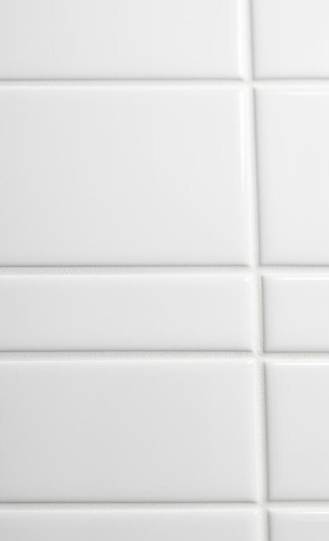 Close-up of white ceramic subway tiles with gray grout.