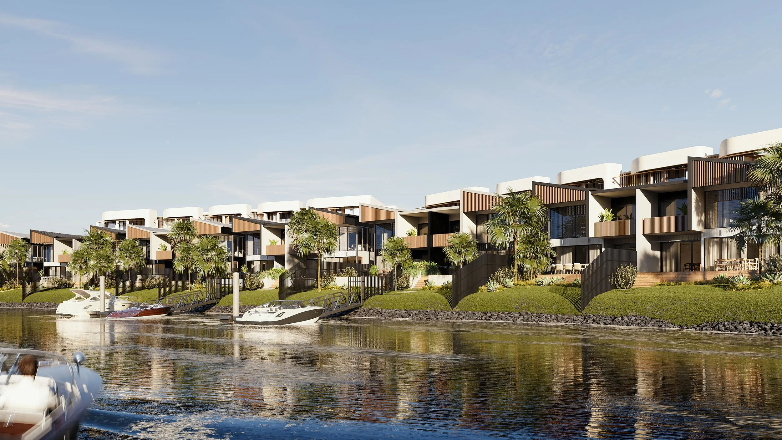 Modern waterfront apartment complex with greenery, palm trees, and a marina with boats on the water.