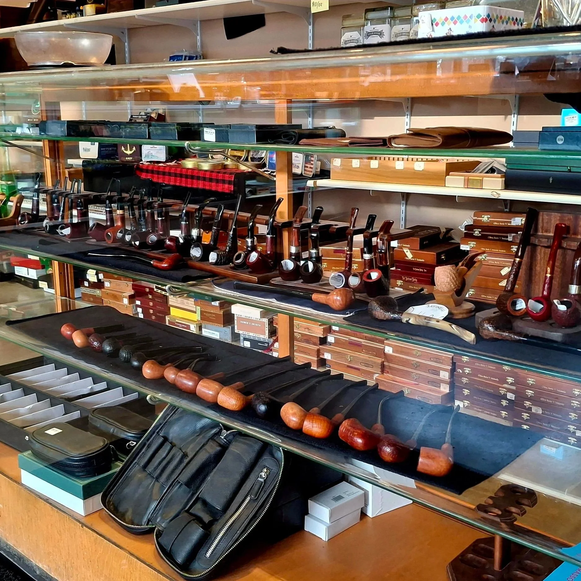 Display shelves with various smoking pipes, cases, and accessories in a shop.