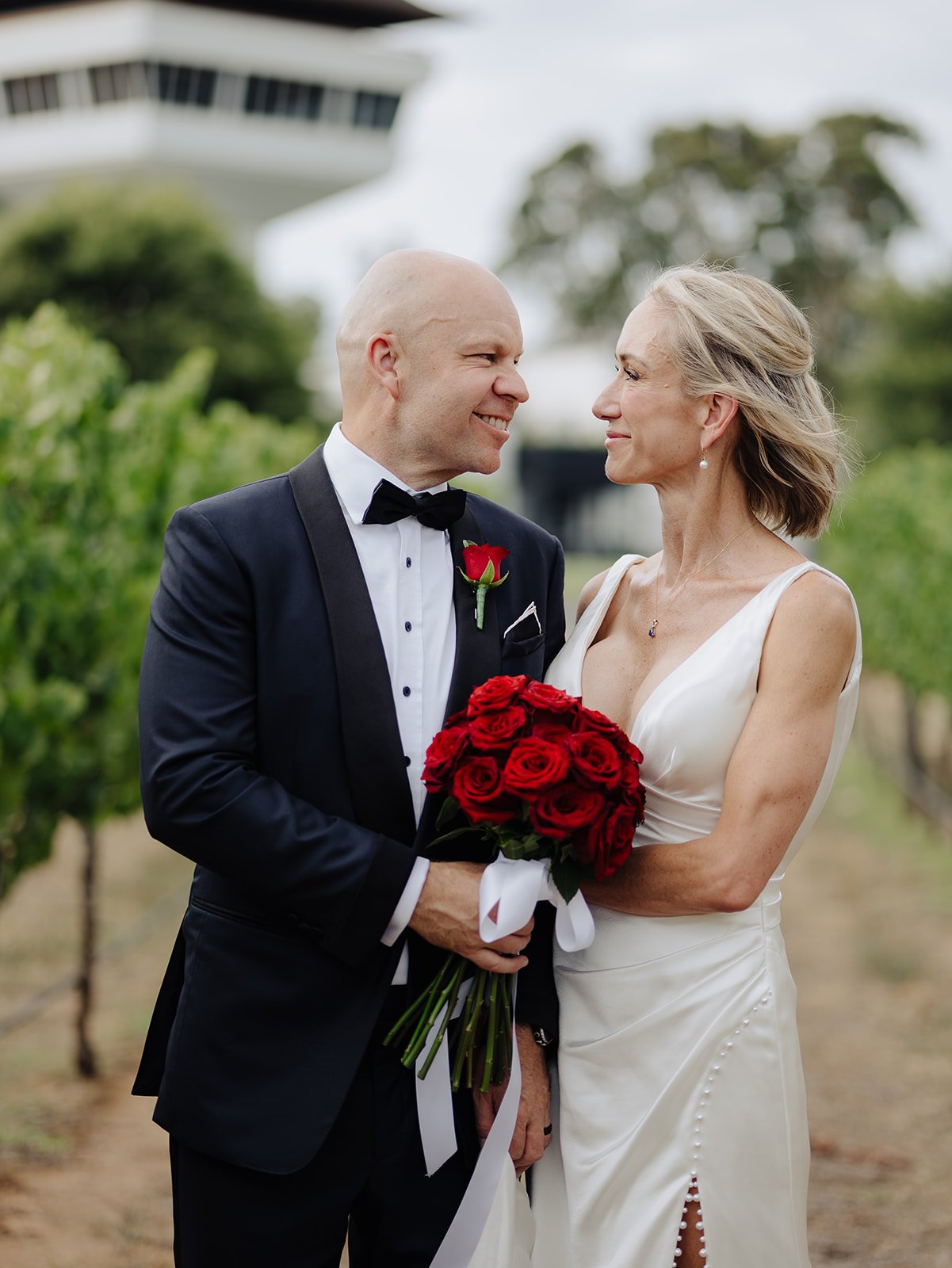 A mature bride posing with her groom for her second wedding in Melbourne. Her makeup and hair are styled in a natural, youthful way and she is glowing and happy. 