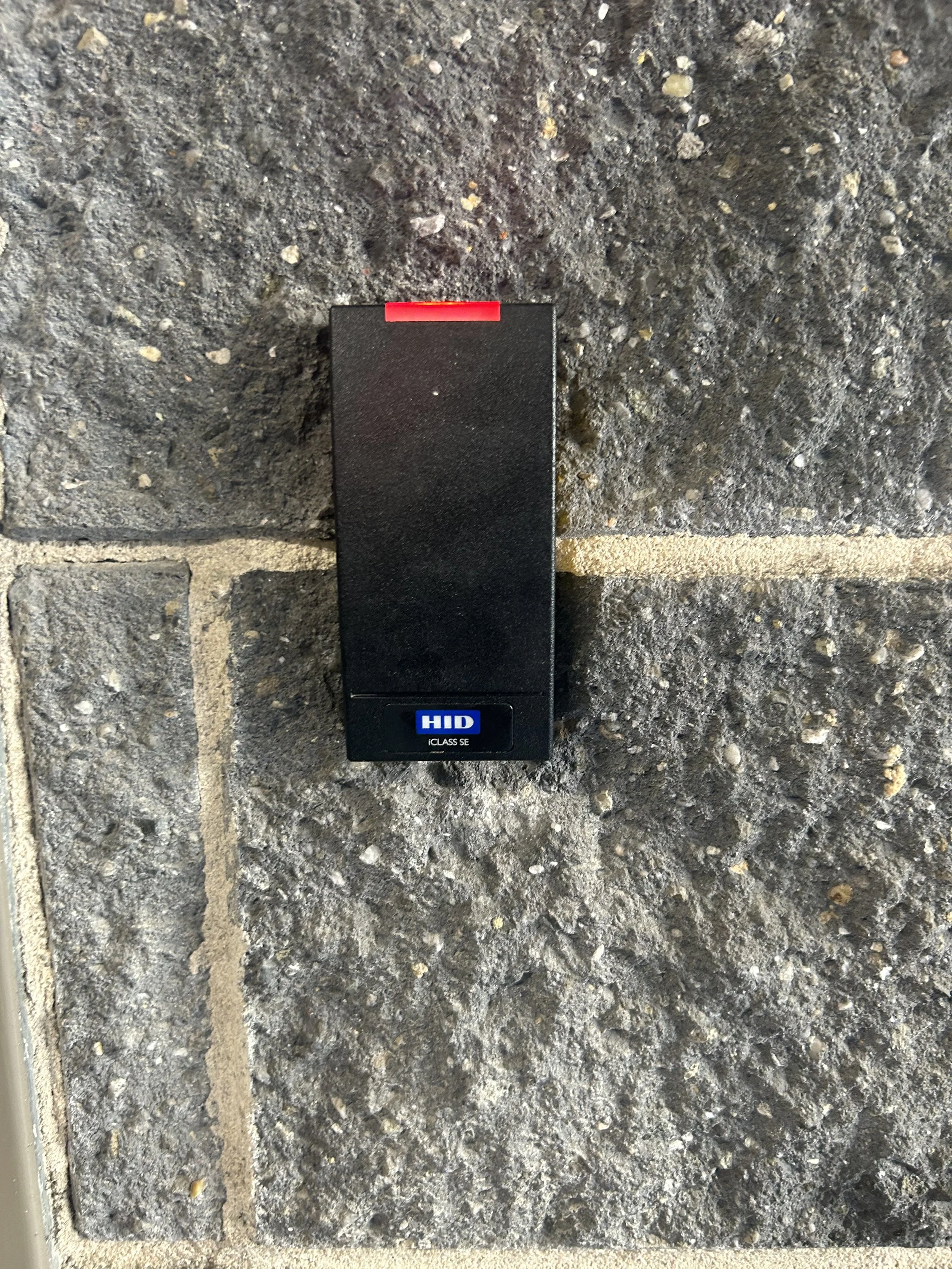 Access control box mounted on a brick wall.