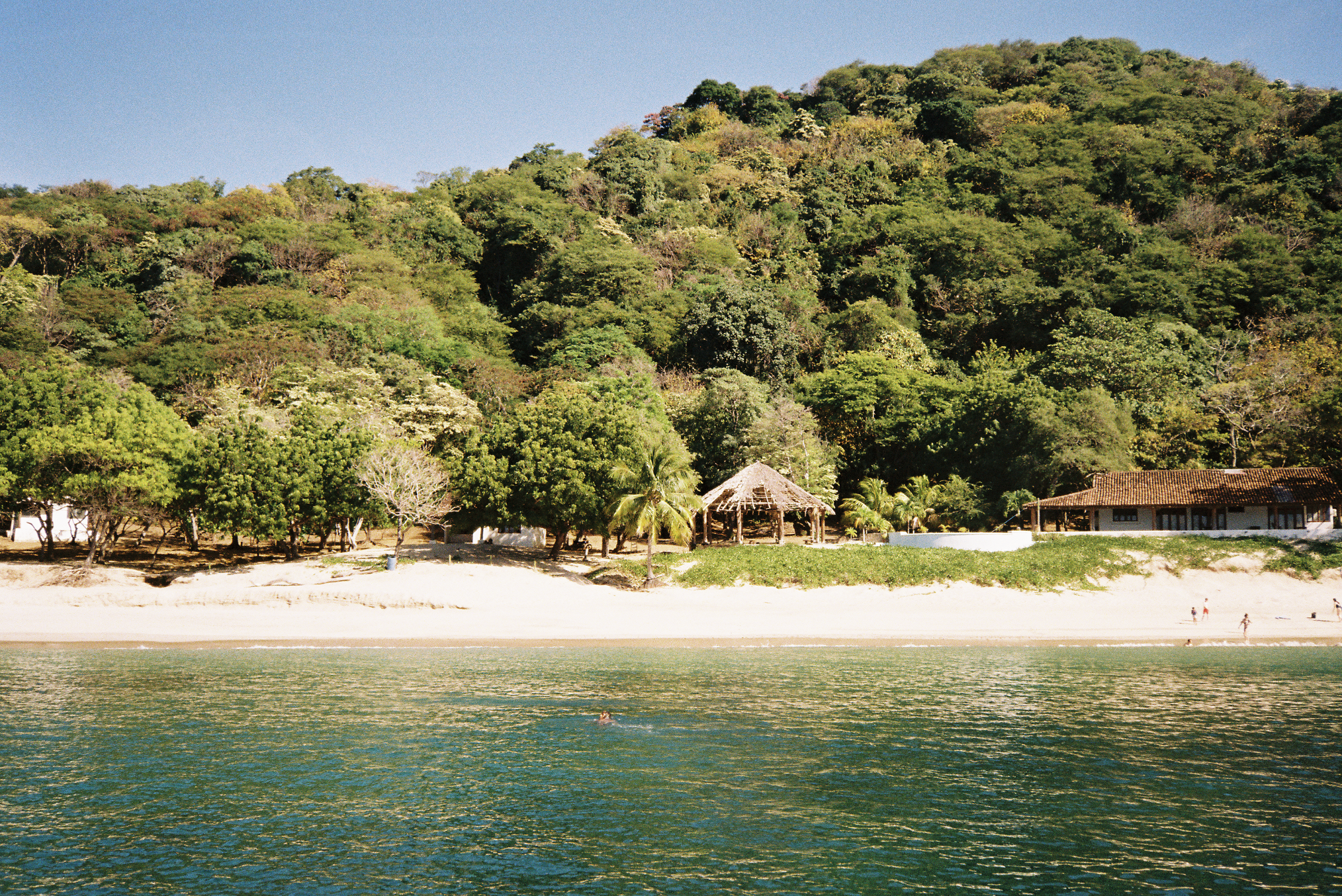 tiki hut on a remote island blue water green trees