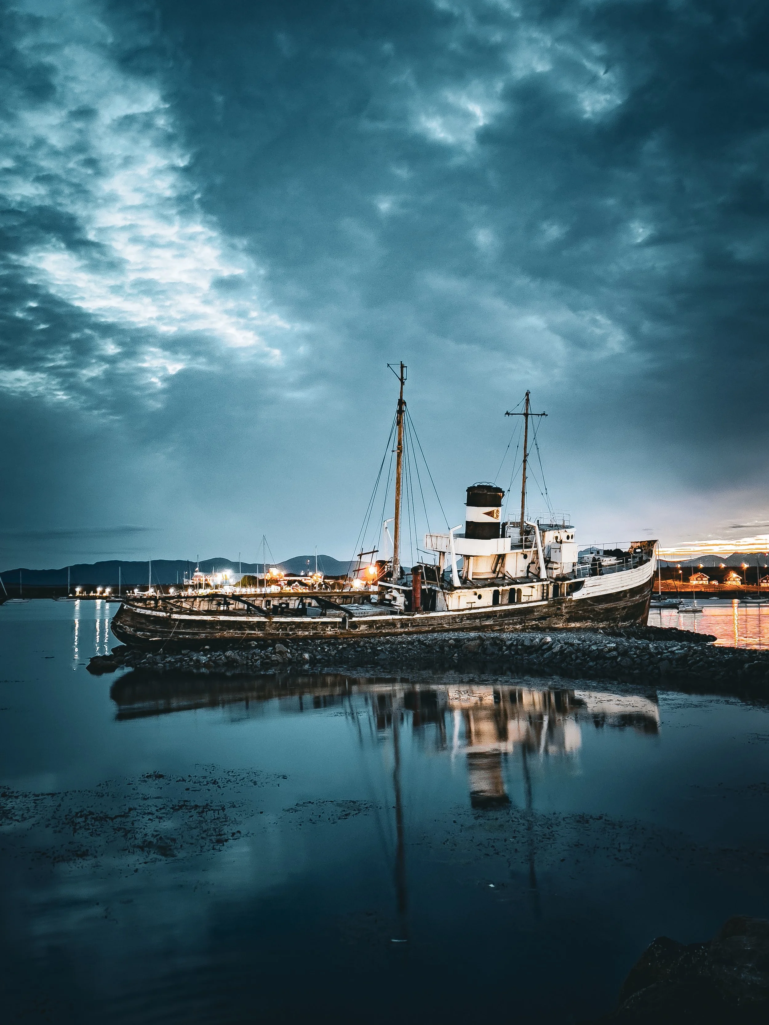 Fishing boat reflected in still water at twilight in Ushuaia, Patagonia, Argentina. Photography by Thomas Dohm.