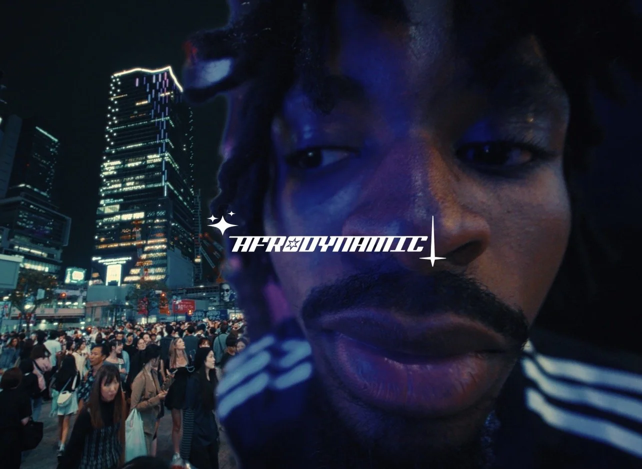 Close-up of a man's face with a cityscape background at night, neon lights, and crowd, with the text 'HFRADYAMTIC' across the image.