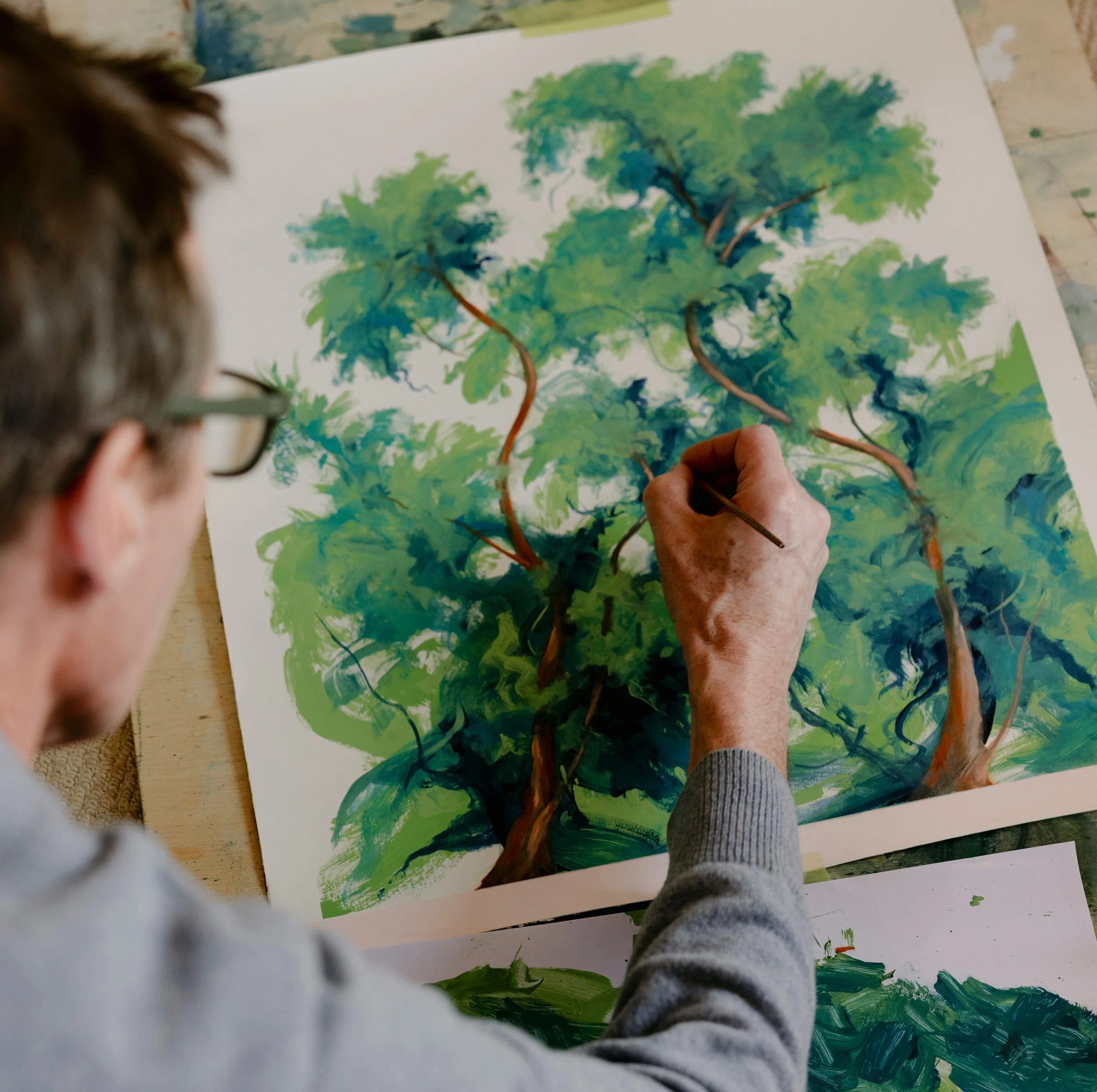 Artist Thomas Mollo creating a painting of trees in his studio