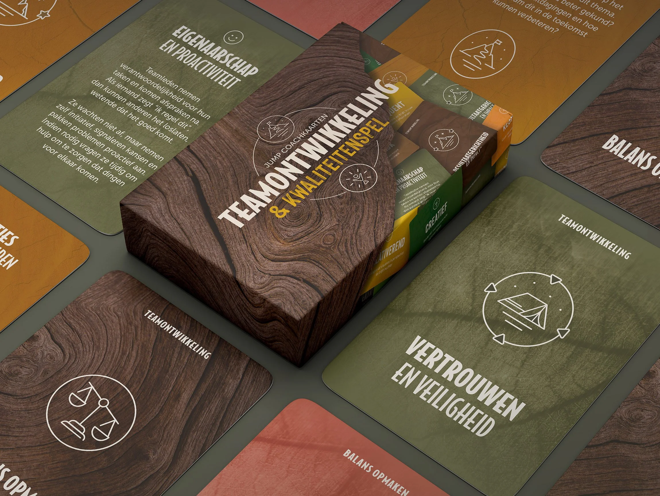 Packaging box of jump coaching cards with the title "Teamontwikkeling & KWALITEITSGAME" on a wooden texture background, surrounded by what appear to be cards with Dutch text and icons related to team development and collaboration.