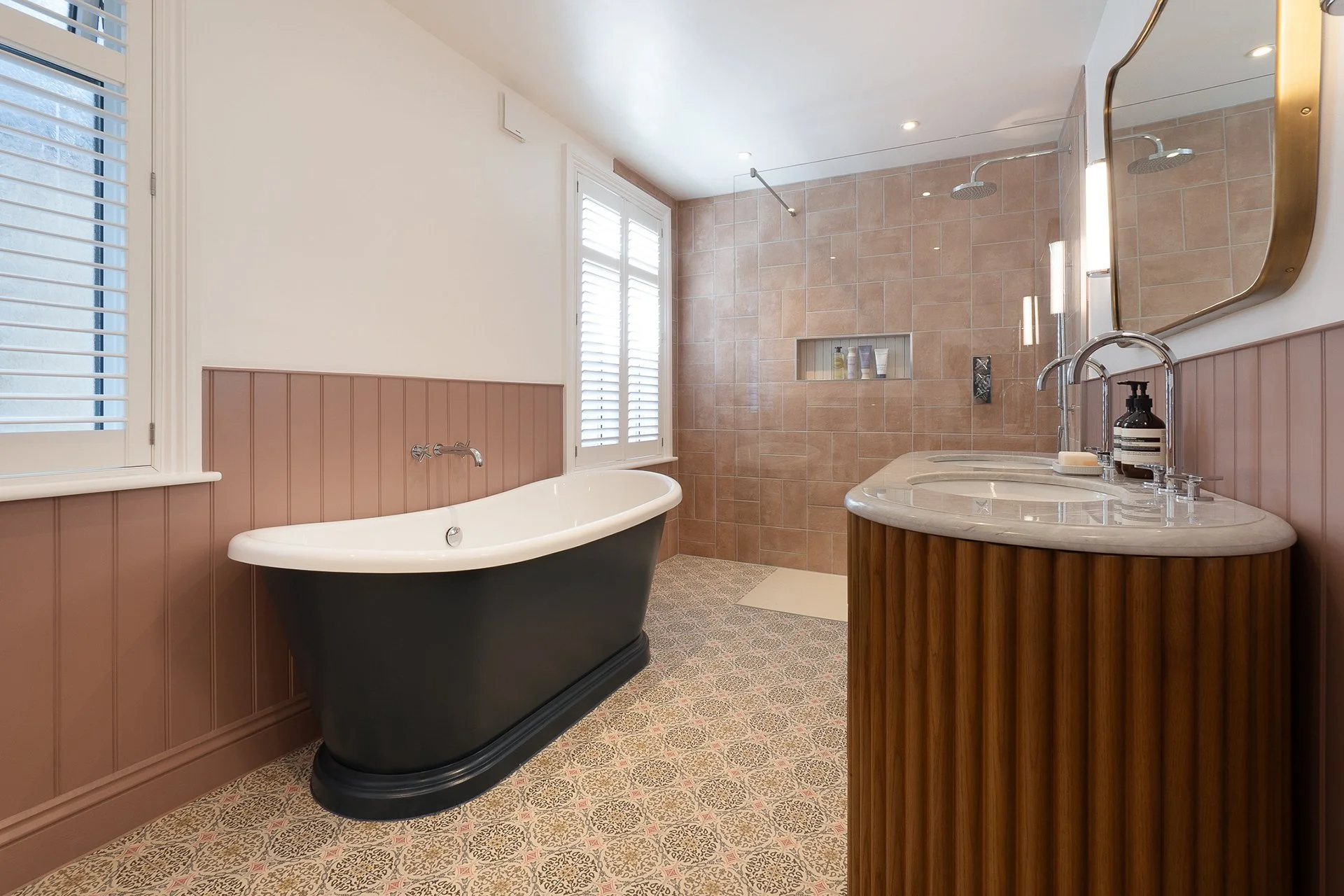 Bathroom with bathtub, vanity with sink, and a walk-in shower with beige tiles.