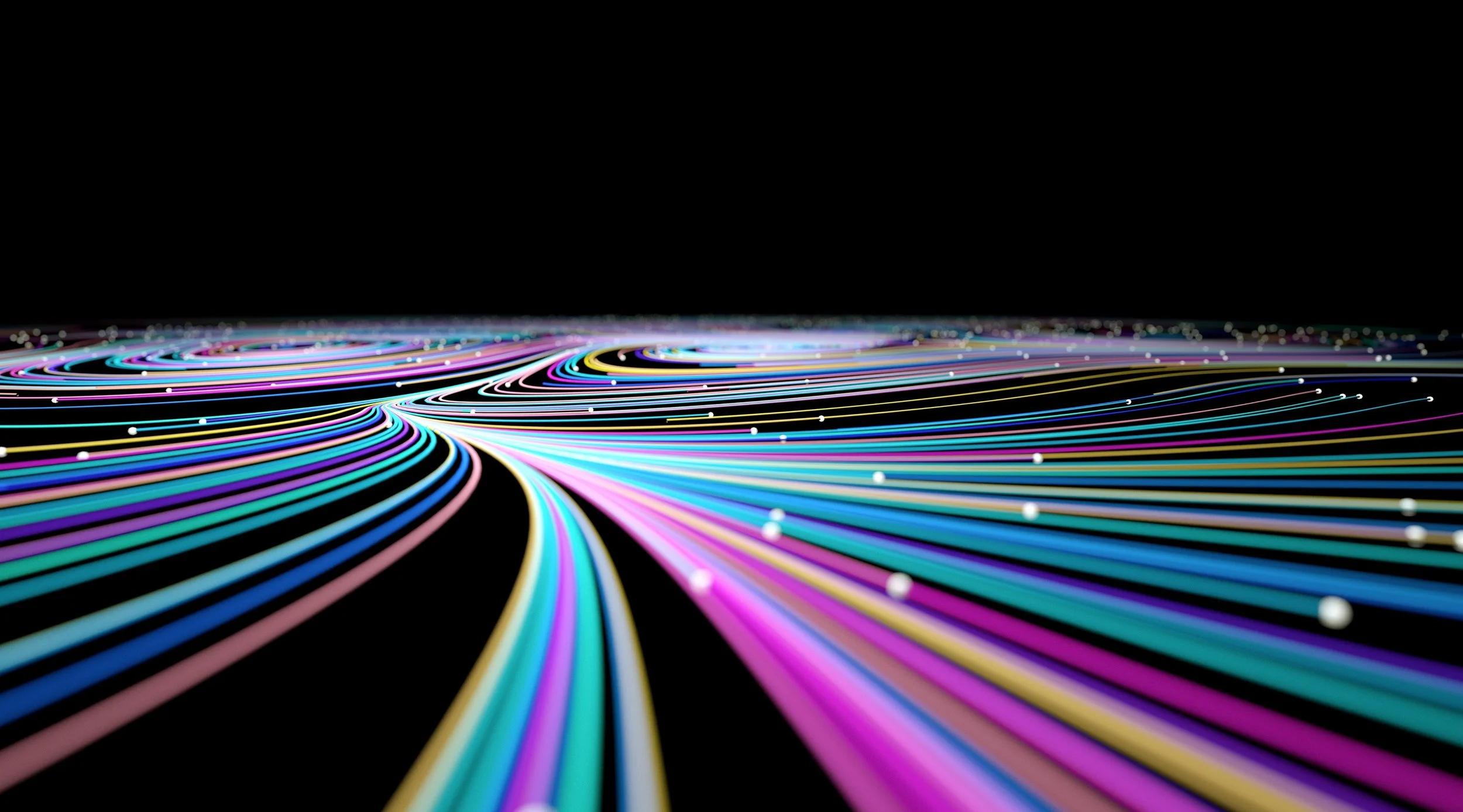 Colorful illuminated fiber optic cables aligned on a dark background, creating a sweeping pattern of bright, multicolored lines.