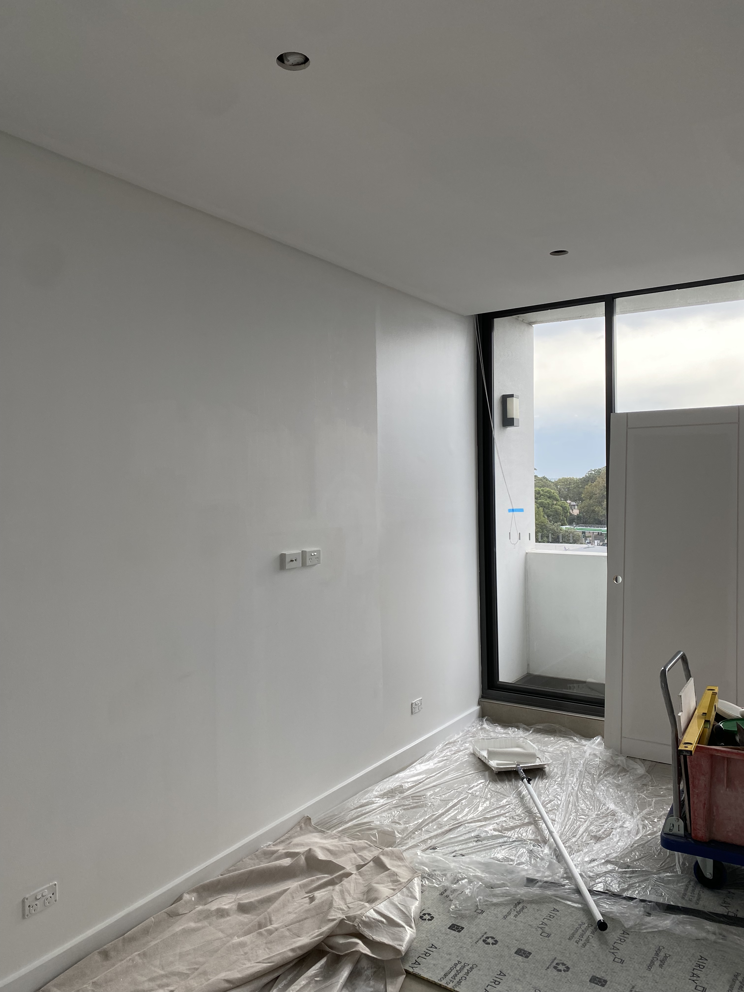 Interior wall painting in Sydney apartment with clean white finish and preparation detail