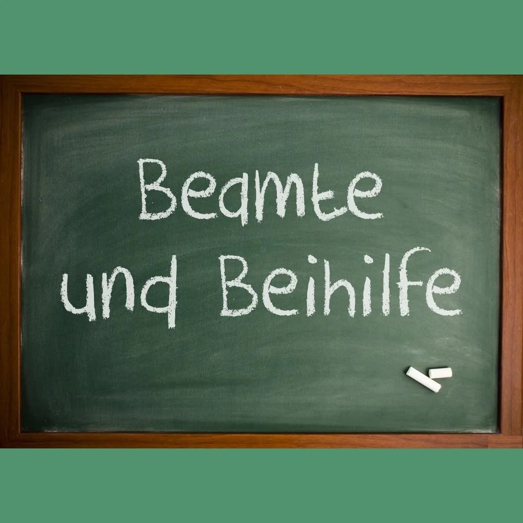 Kreidebeschriftete Schultafel mit dem Text "Beamte und Behilfe"