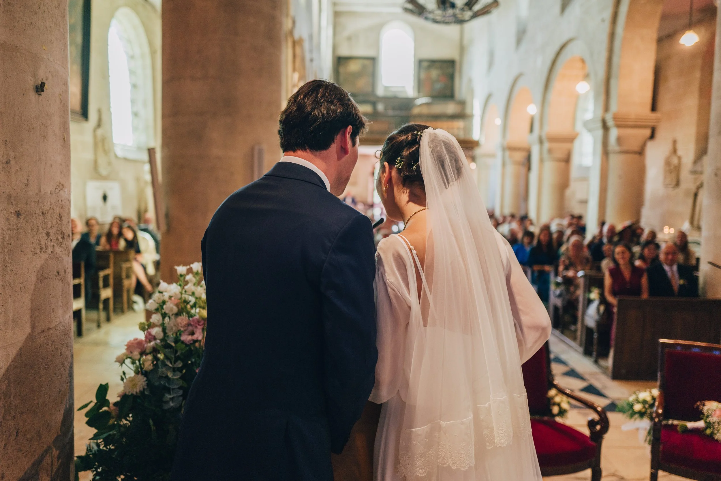 Photographie d'un couple de mariés de dos, lors d'un mariage religieux à l'église
