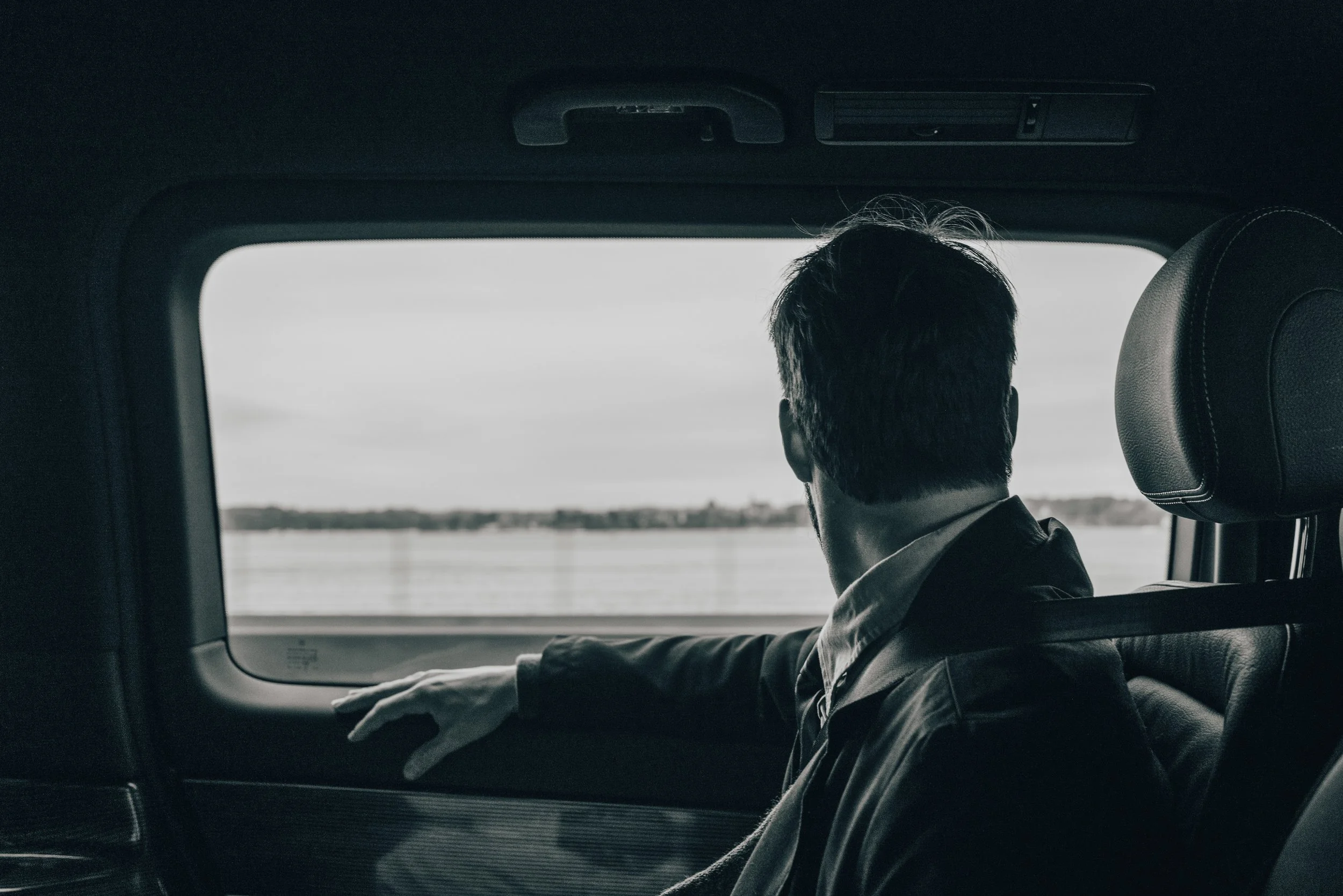 Photo cinématographique d'un homme regardant par la fenêtre de sa voiture