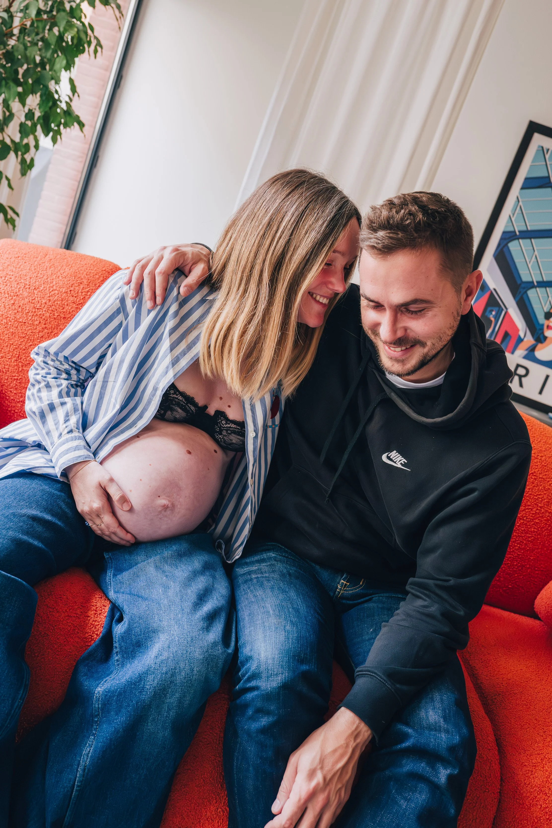 Photographie d'un couple enceinte dans un appartement parisien.