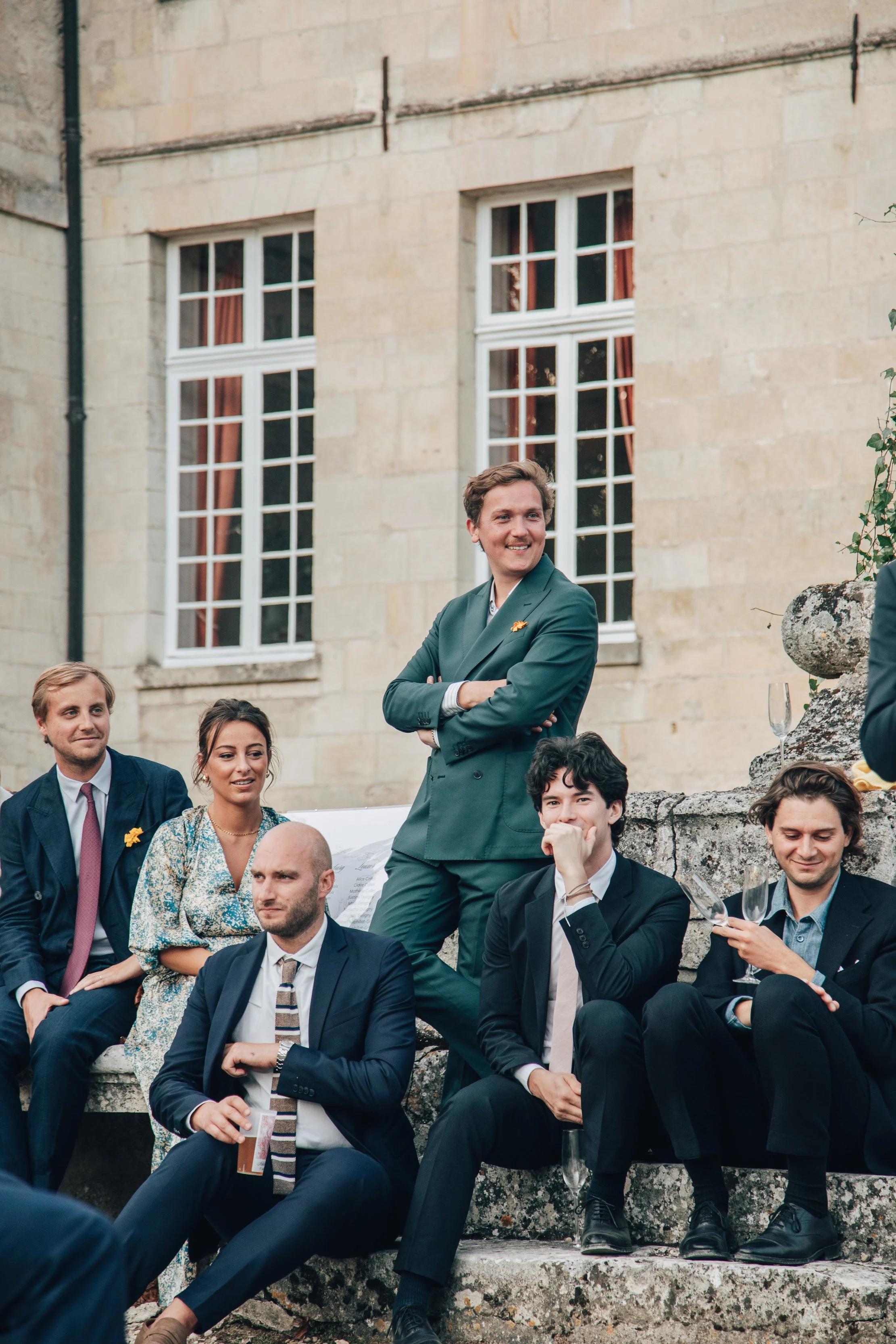 Groupe de personnes assises lors d'une journée de mariage dans un domaine privé