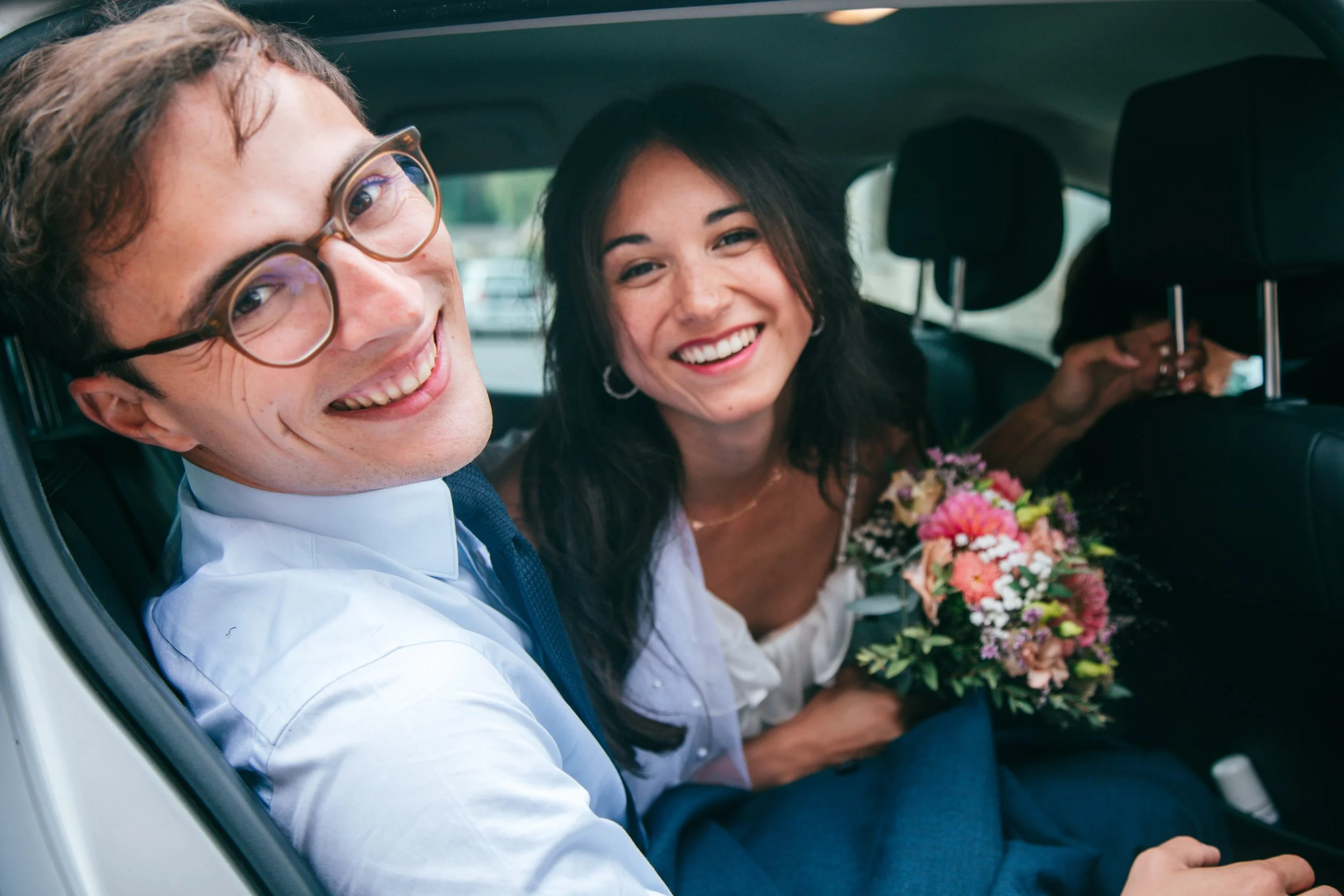 Jeune couple de mariés dans leur voiture