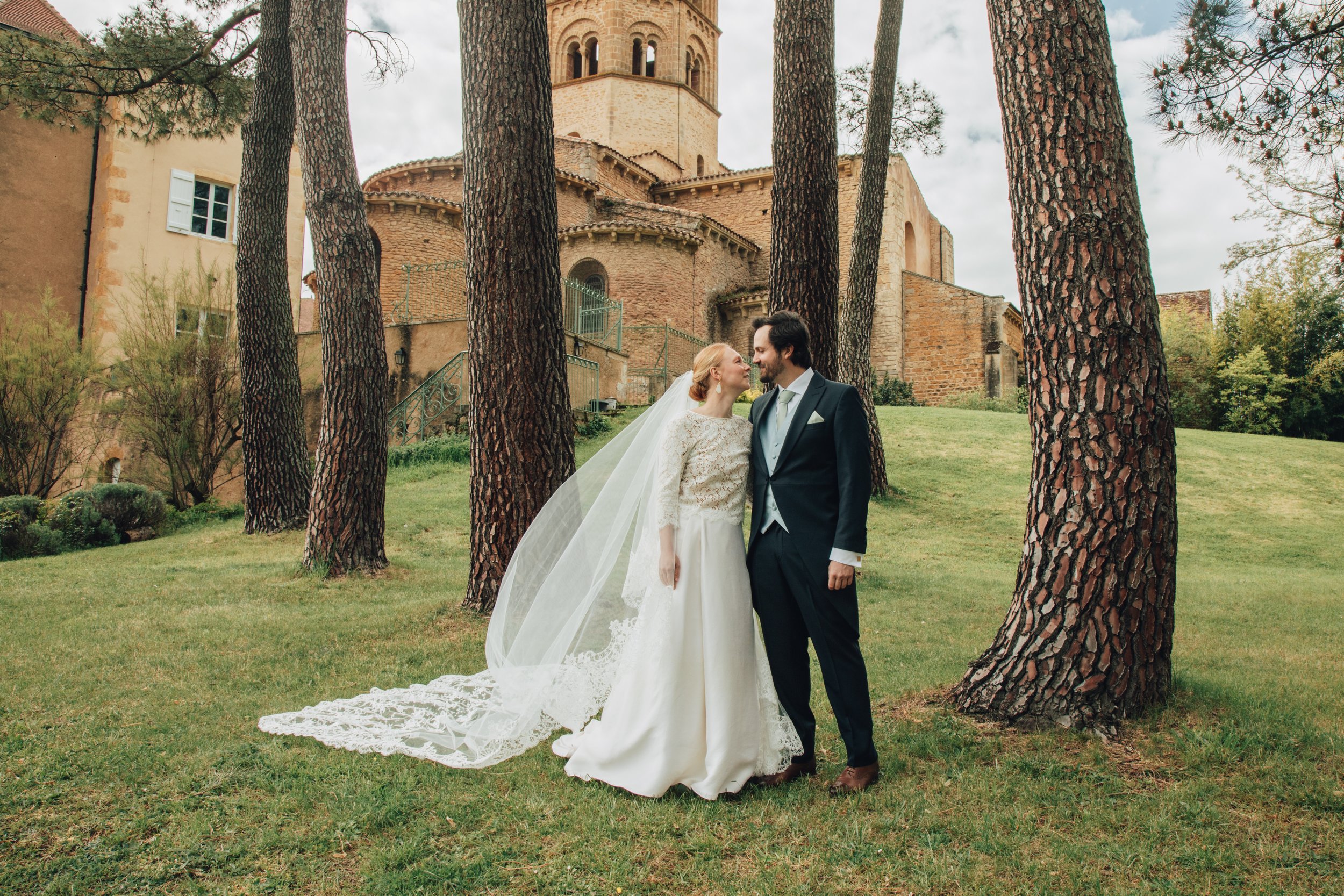 Photographie d'un jeune couple de mariés dans le parc verdoyant d'un domaine