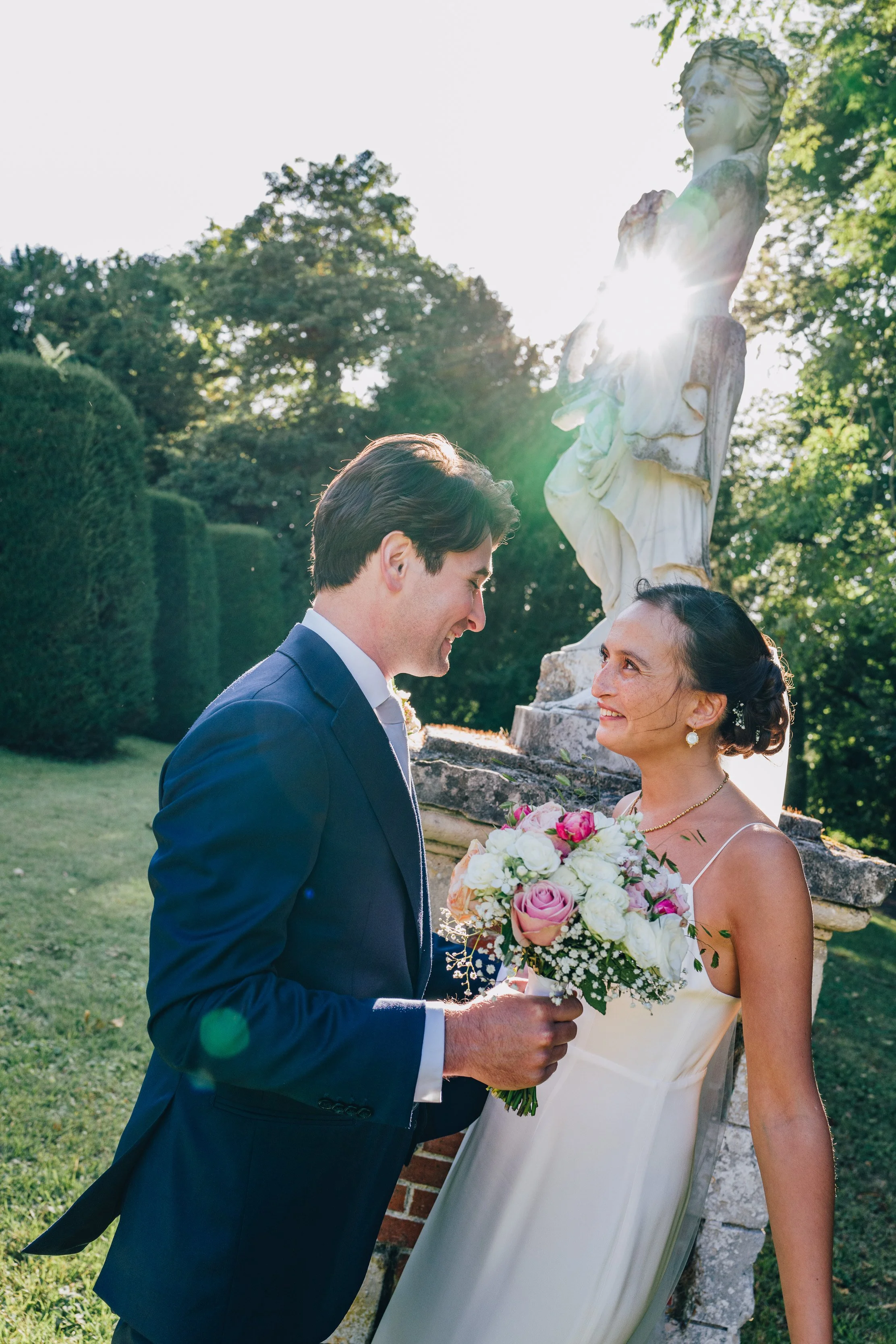 Photographie d'un couple de jeunes mariés dans un parc verdoyant