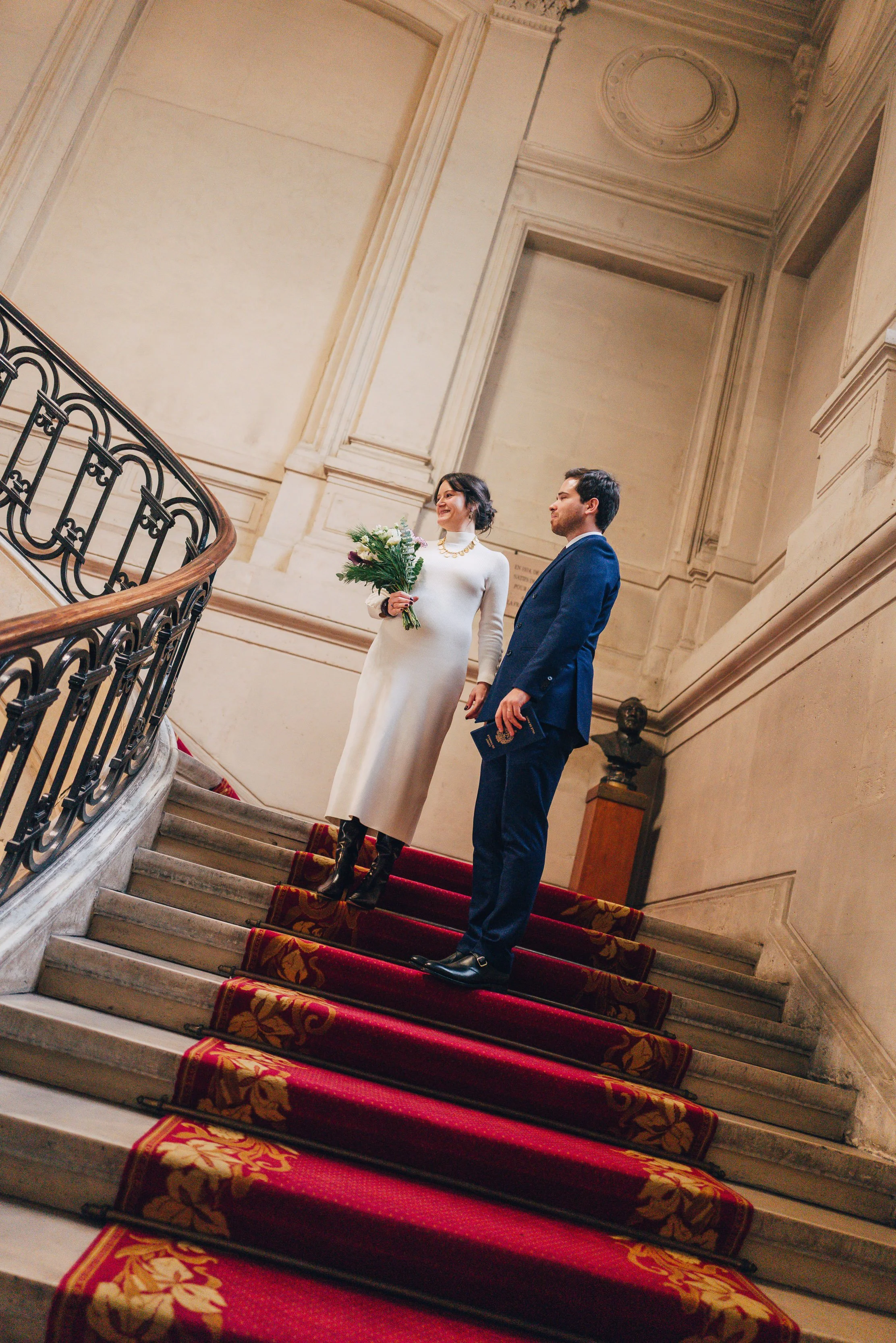Photographie d'un couple de futurs mariés dans les marches de la mairie 