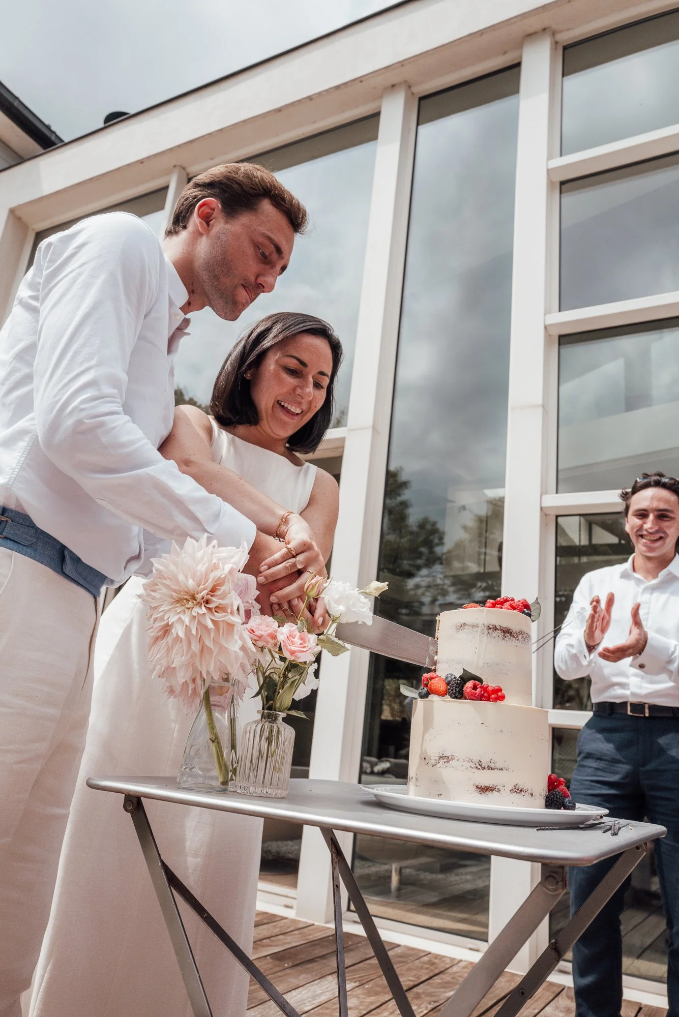 Photographie d'un couple de mariés qui découpent le dessert