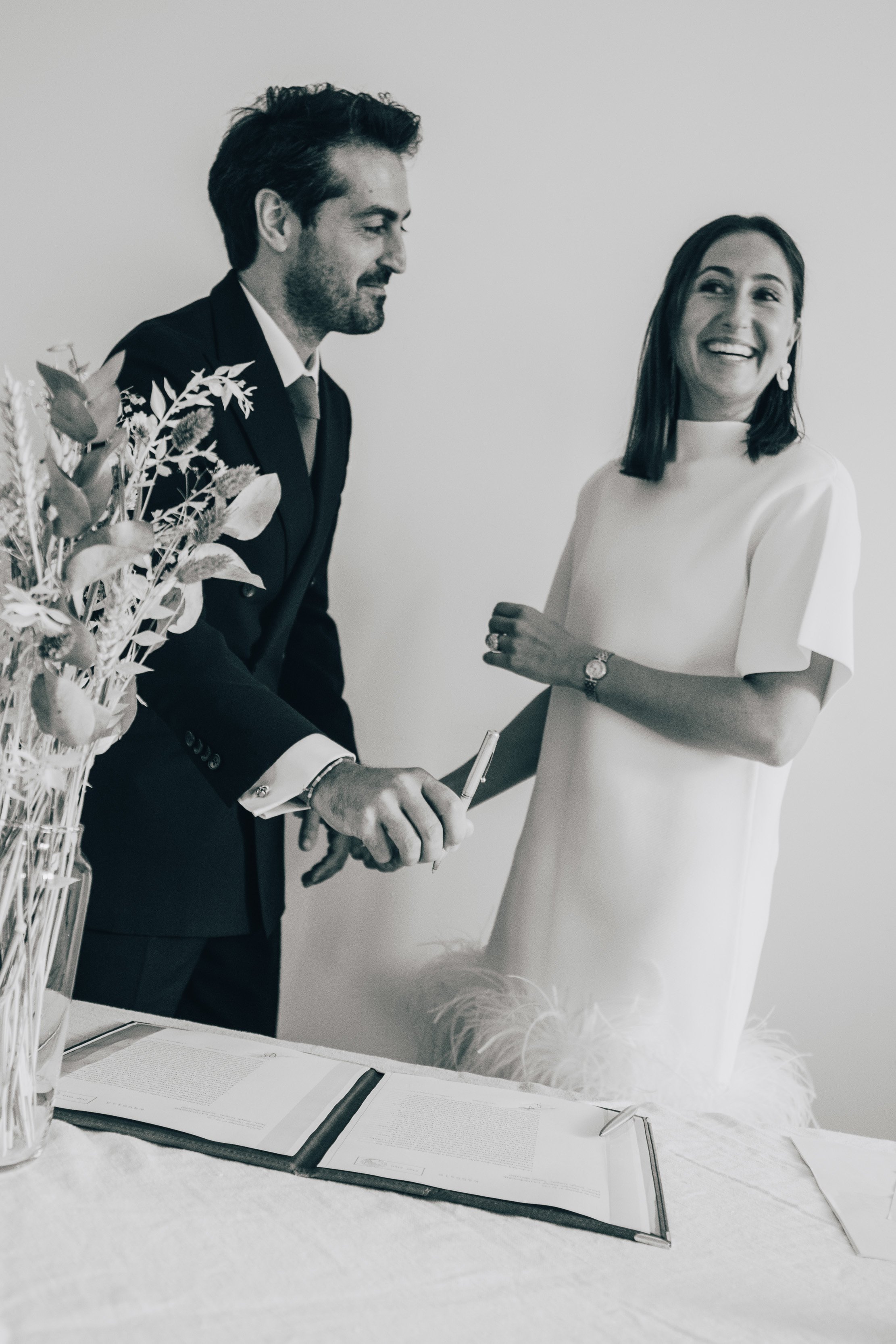 Photographie noir et blanc de la signature par les mariés des registres de l'état civil à la mairie 