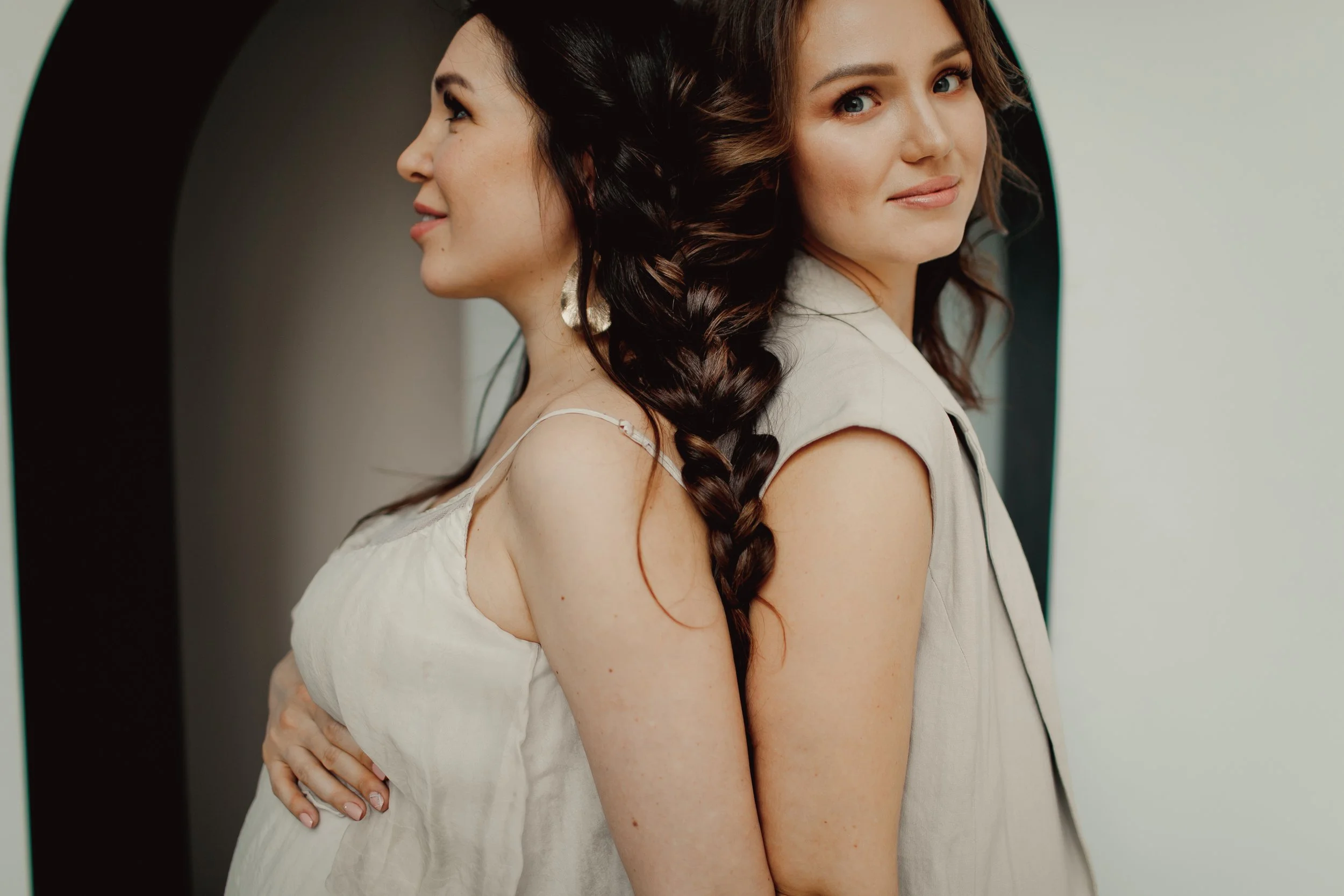 Doula embracing a pregnant woman in soft natural light – fourth trimester and lactation support