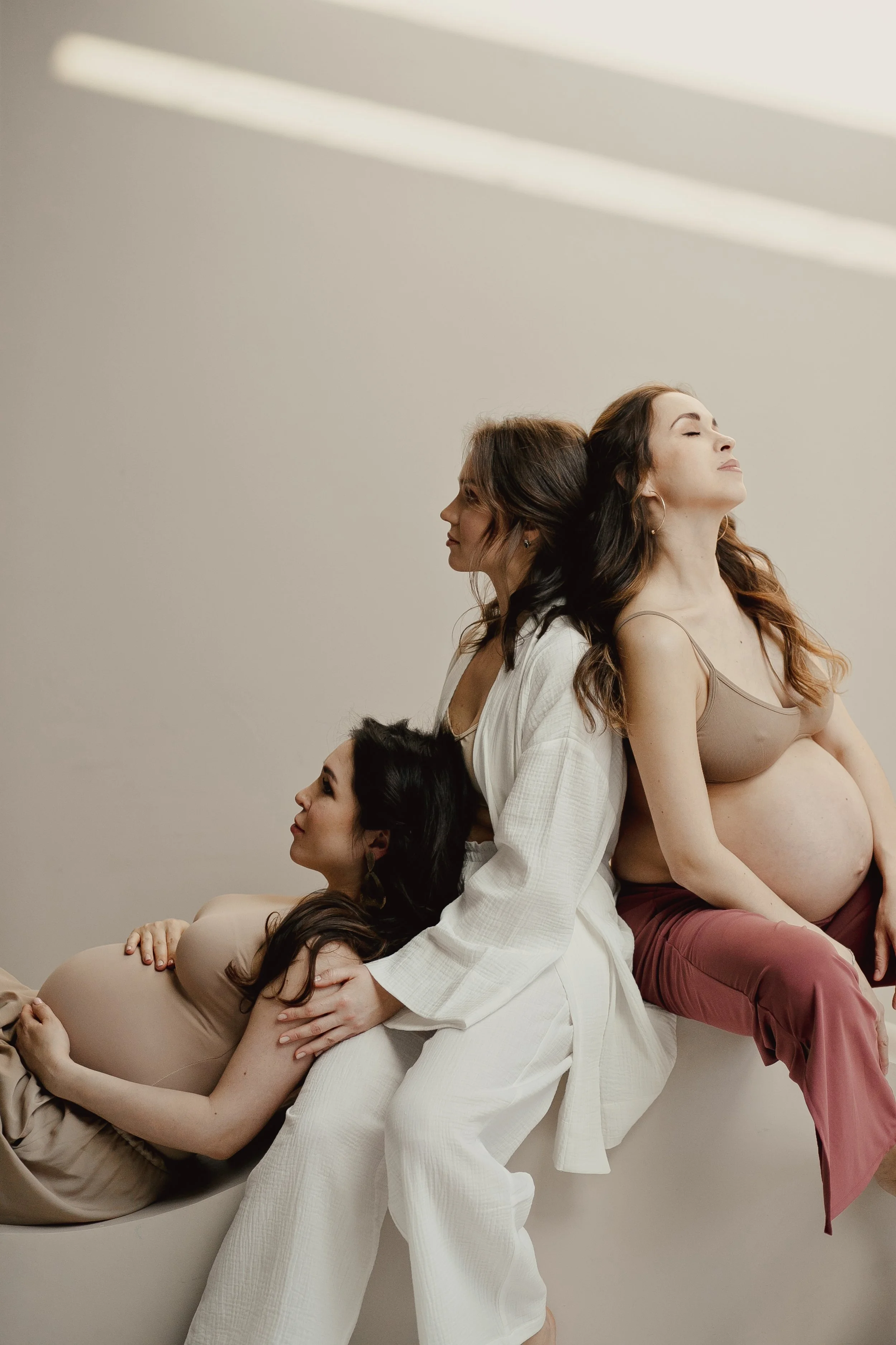 Doula sitting with two pregnant women, offering calm support