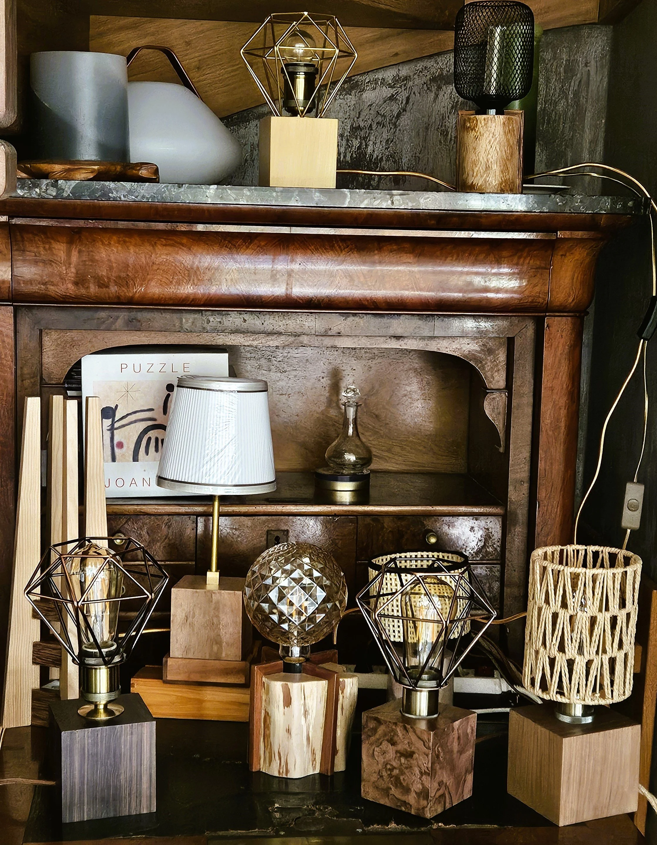 Une étagère en bois avec diverses décorations, notamment des lampes, des livres, et des objets en verre et en bois.