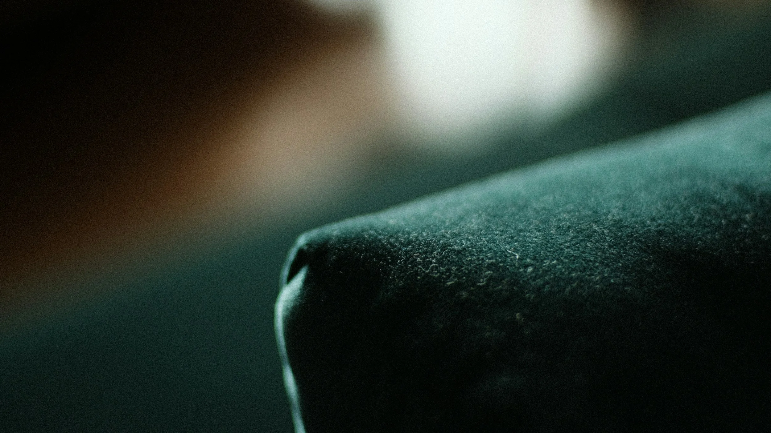 Close-up of a dark green chalkboard with a piece of chalk resting on its edge.