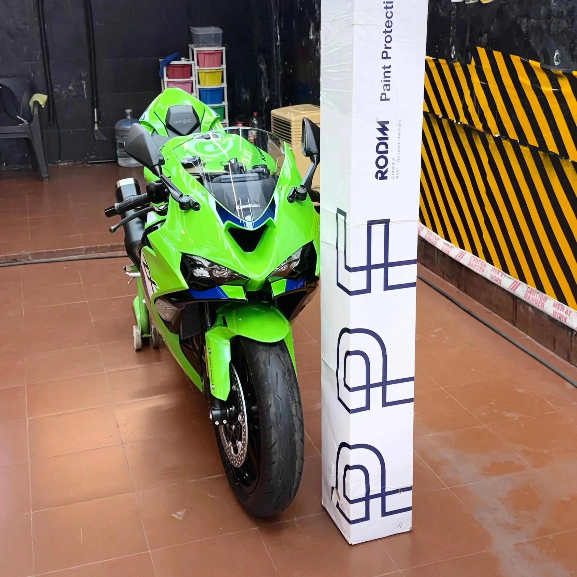 A green Kawasaki sport motorcycle parked indoors after a PPF Application in DETAILED Ghansoli, Navi Mumbai, Near by to Vashi, Turbhe, Airoli.