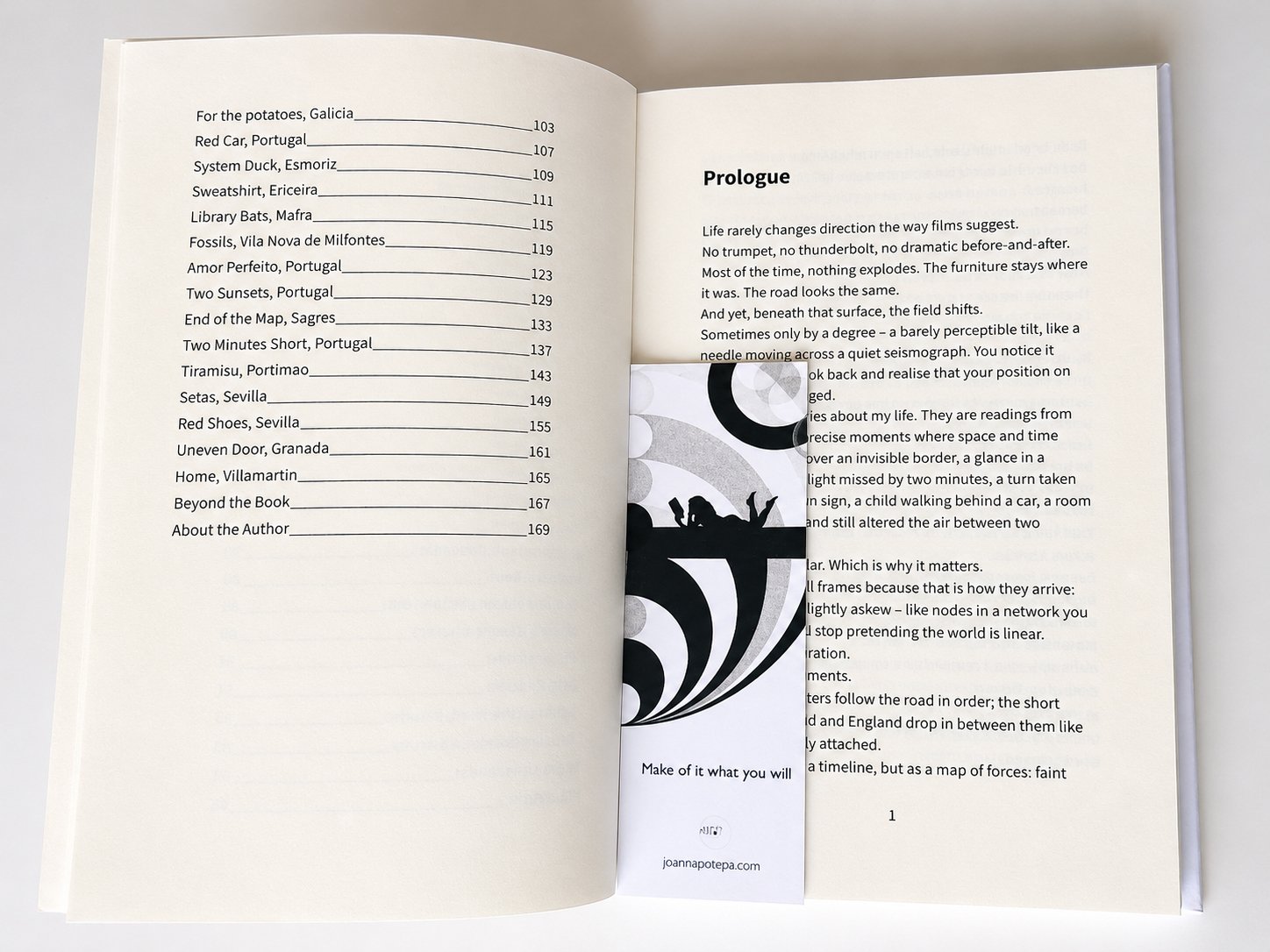 Open hardback copy of It Happened: Make of It What You Will showing interior pages and a matching geometric bookmark.