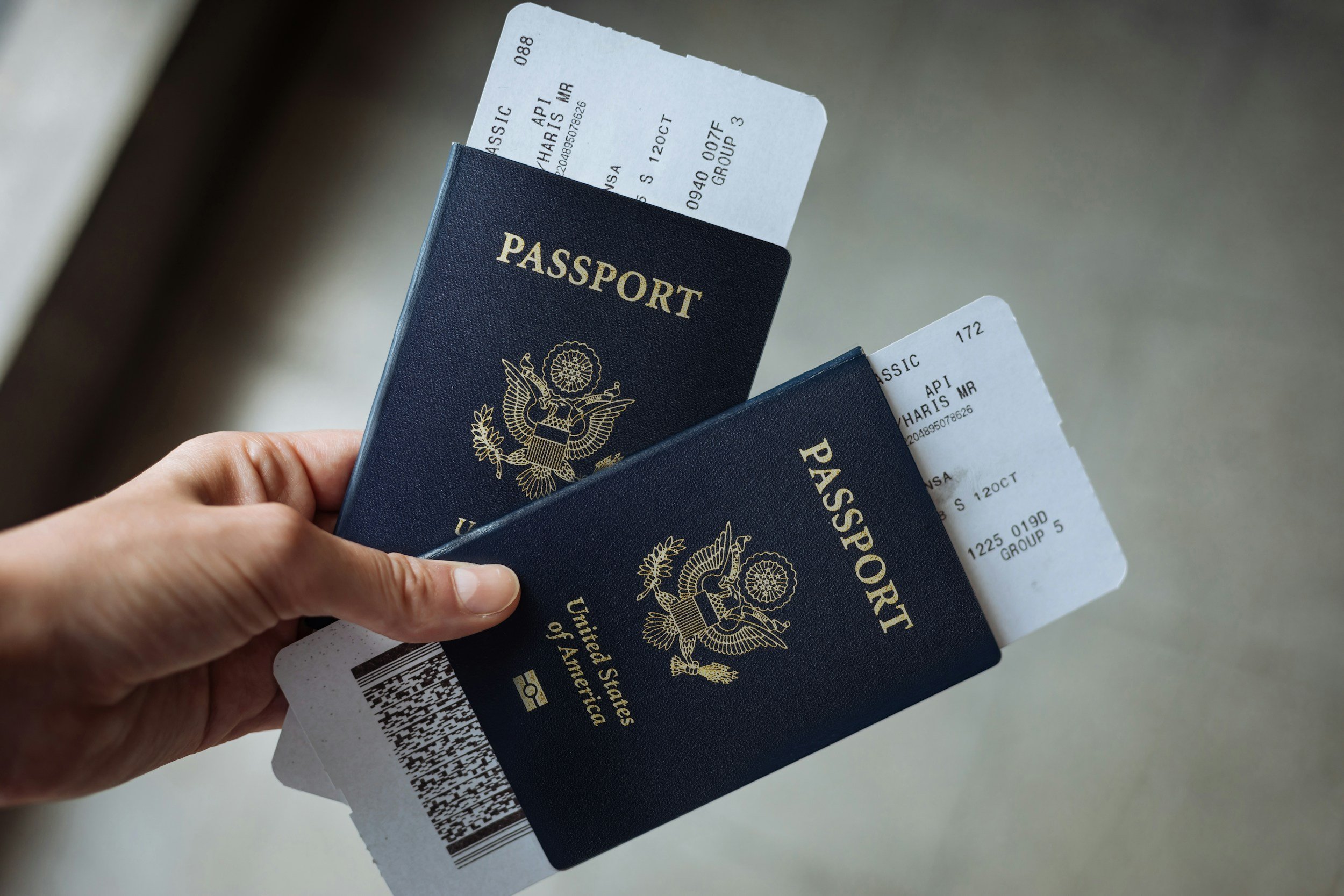 person holding passports and boarding passes