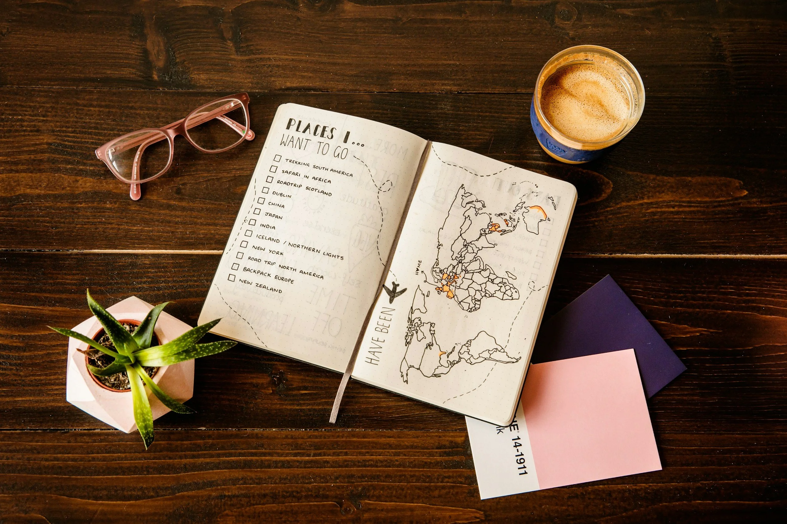 Relaxed travel itinerary planning with notebook, map, and coffee