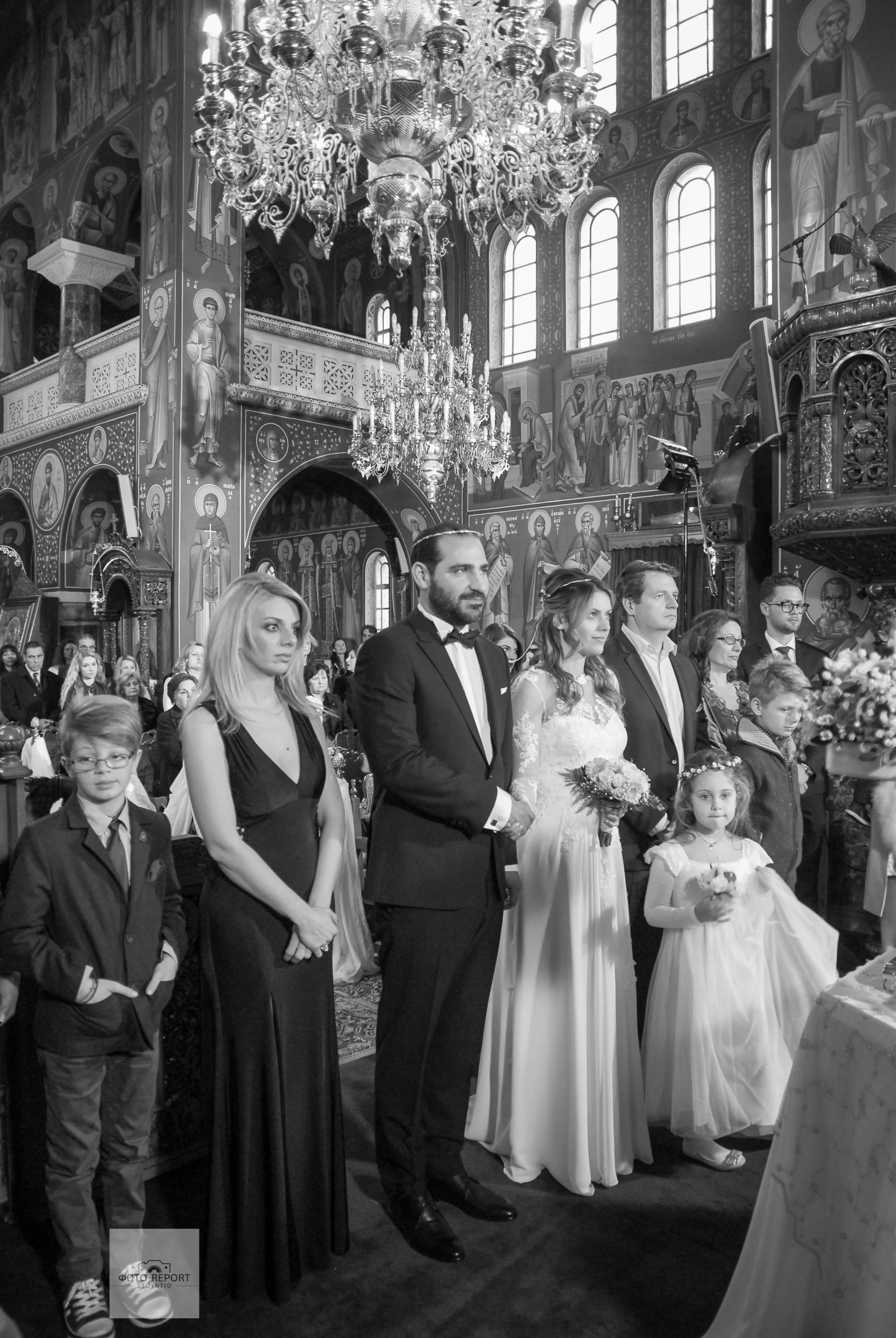 Ασπρόμαυρη φωτογραφία του ζευγαριού κατά τη διάρκεια της τελετής στην εκκλησία. Κάλυψη θρησκευτικού γάμου στην Αθήνα.