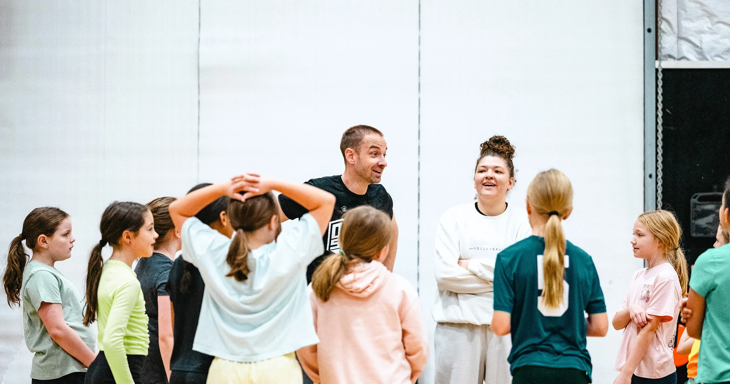 Summer camp group high-fiving coach during team activity in Dripping Springs