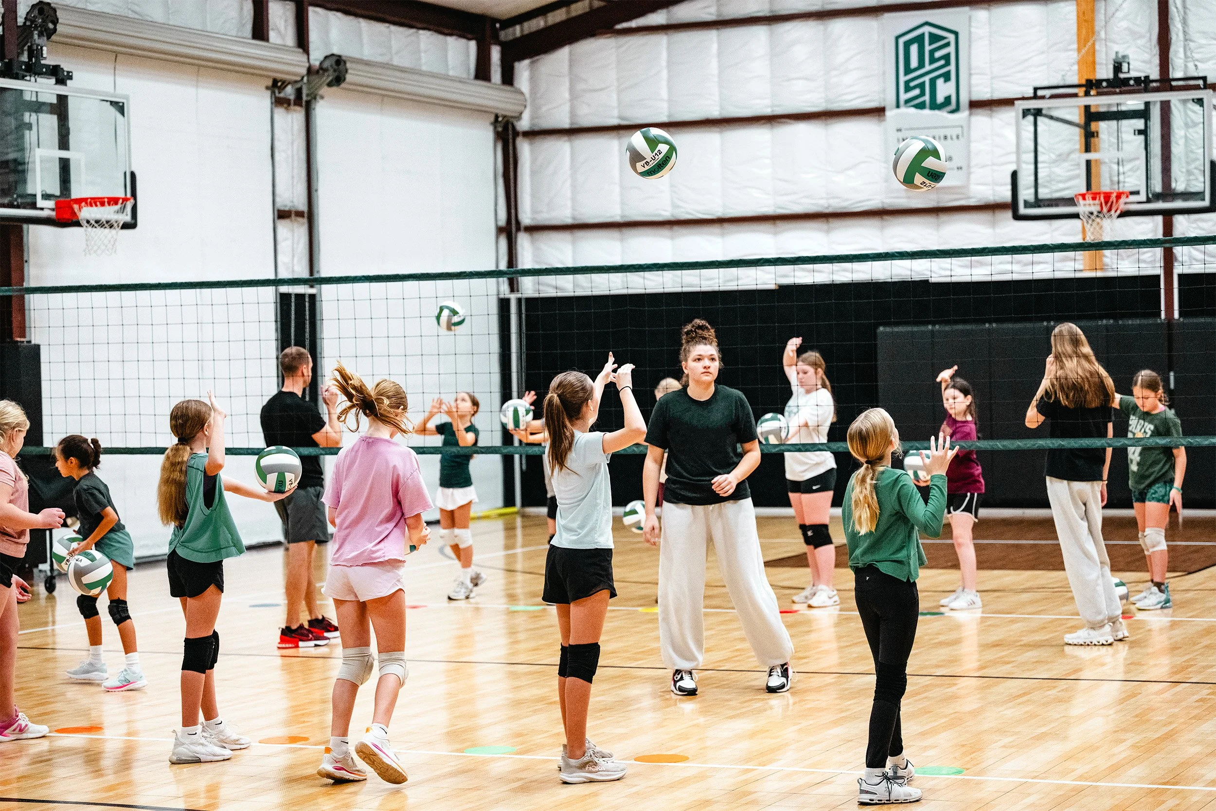 Youth volleyball players participating in active team drill at clinic in Dripping Springs, TX
