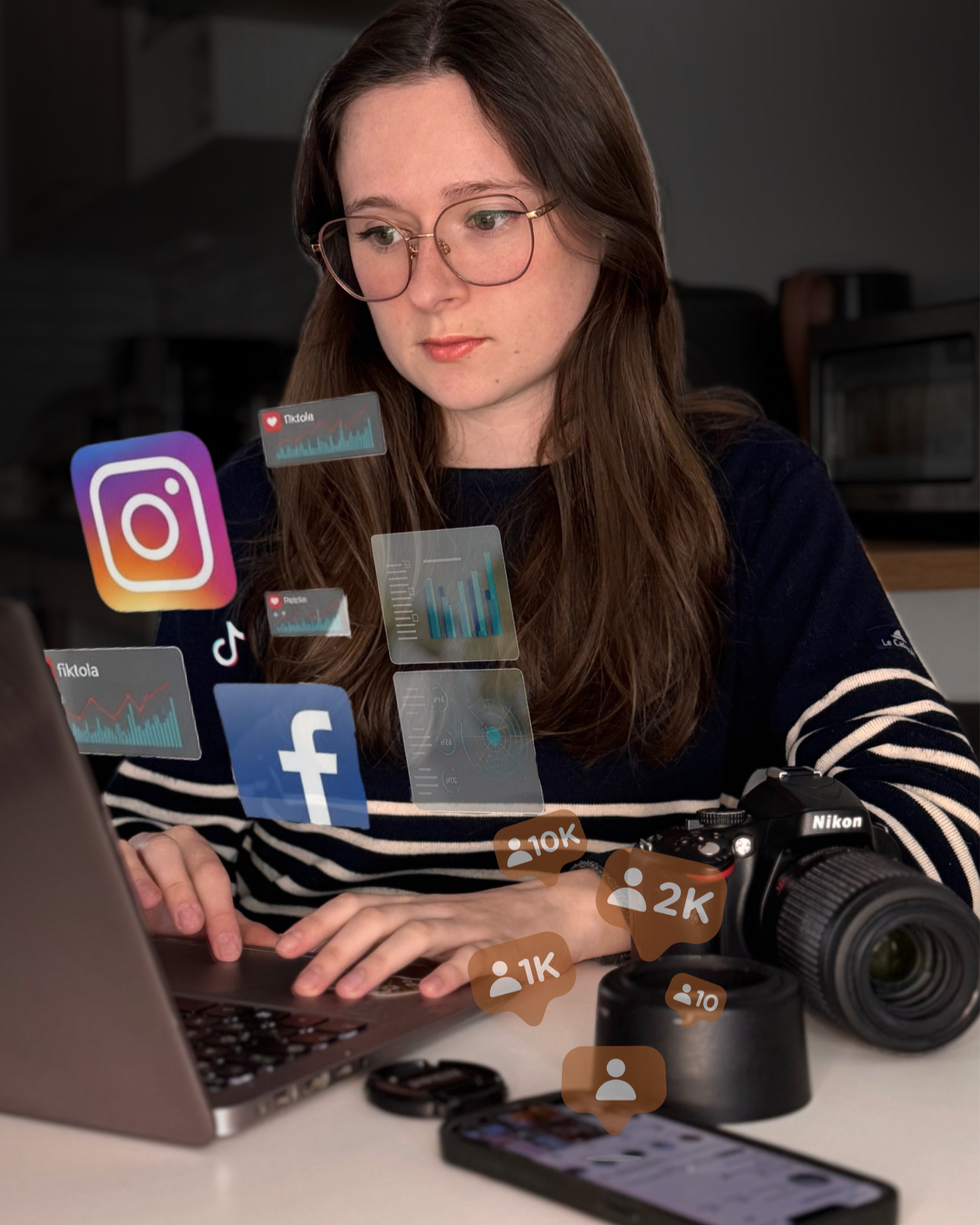 Femme brune à lunettes en train d'écrire à son ordinateur.