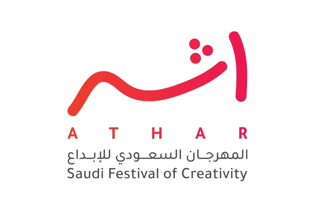 Logo for the Saudi Festival of Creativity with red and pink abstract design and text in Arabic and English.
