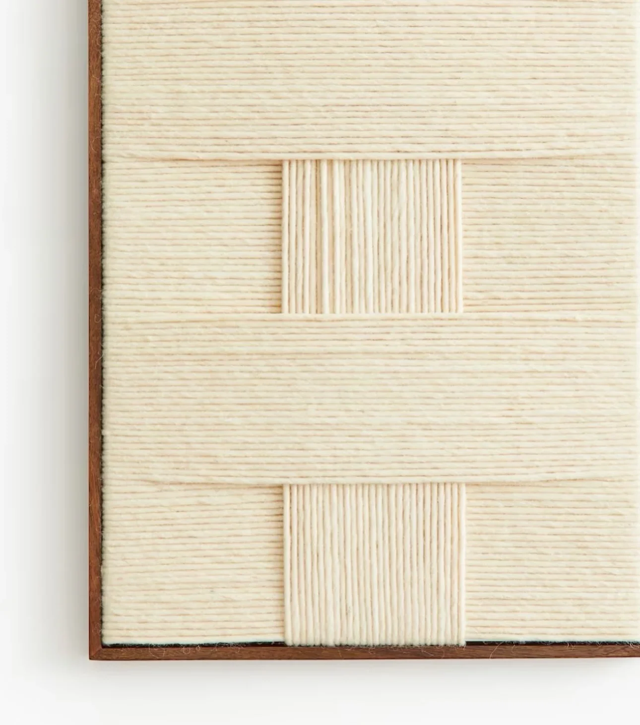 Close-up of a wooden board with three square, ribbed, cream-colored tiles arranged in a vertical line.