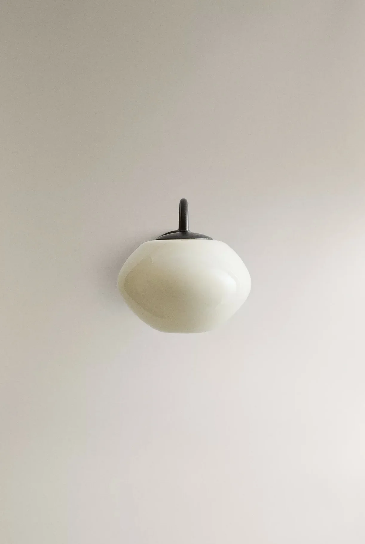 A ceiling-mounted white and black pendant light fixture against a white ceiling.