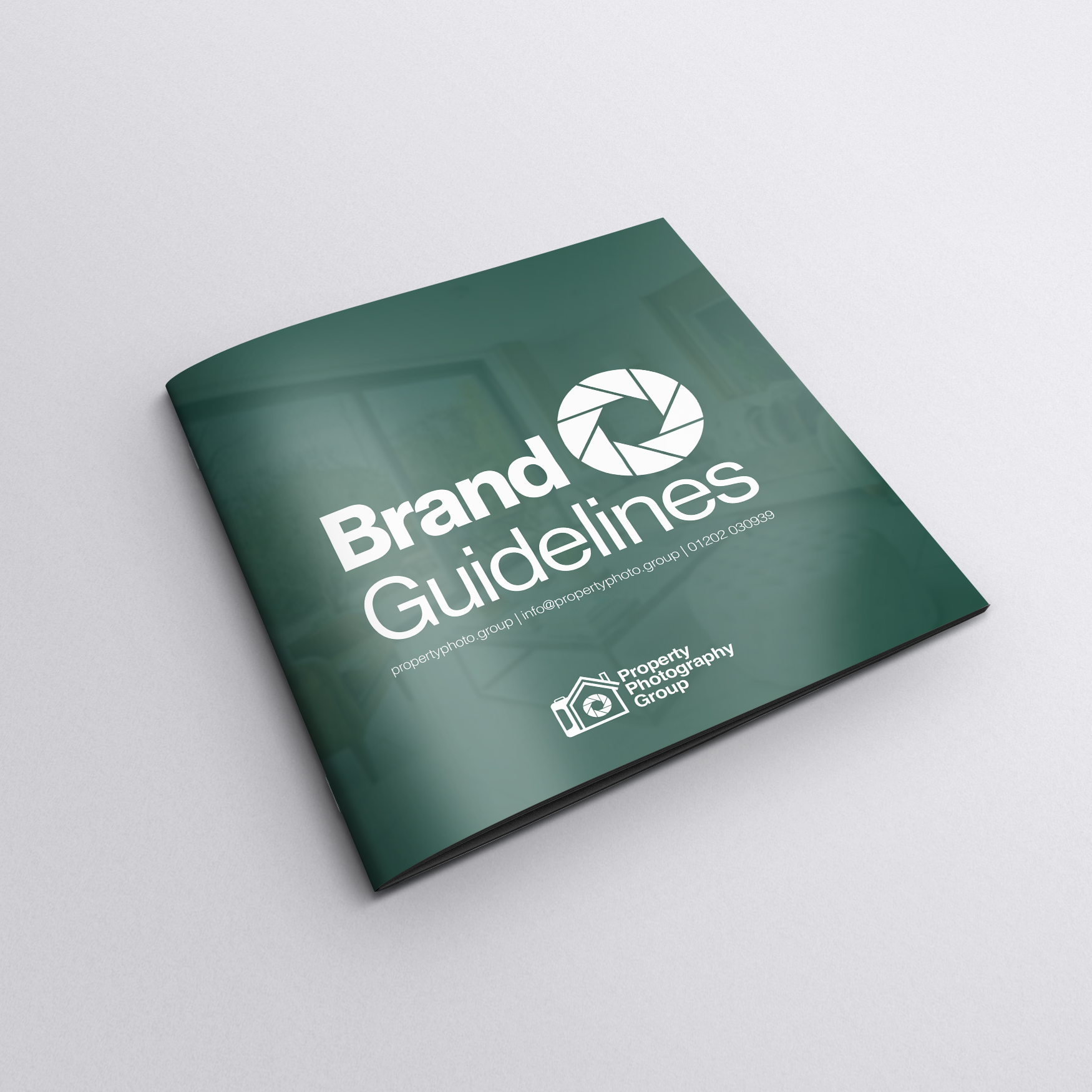 A green brochure titled "Brand Guidelines" with a camera shutter icon, placed on a white surface.